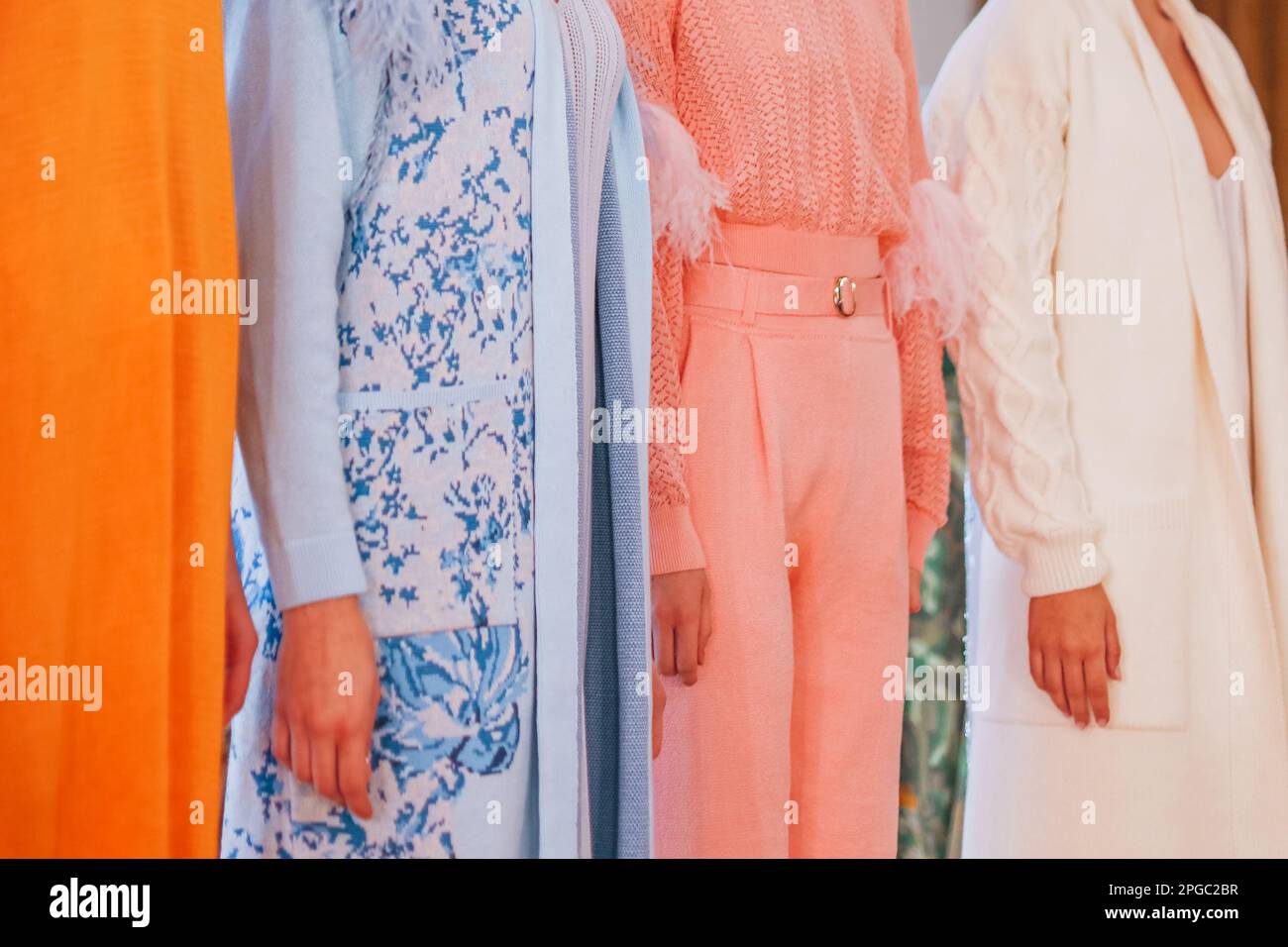 Verkürzte weibliche Figuren in pinkblauer, weißer, stilvoller Herbstbekleidung auf der Backstage Fashion Week. Stockfoto