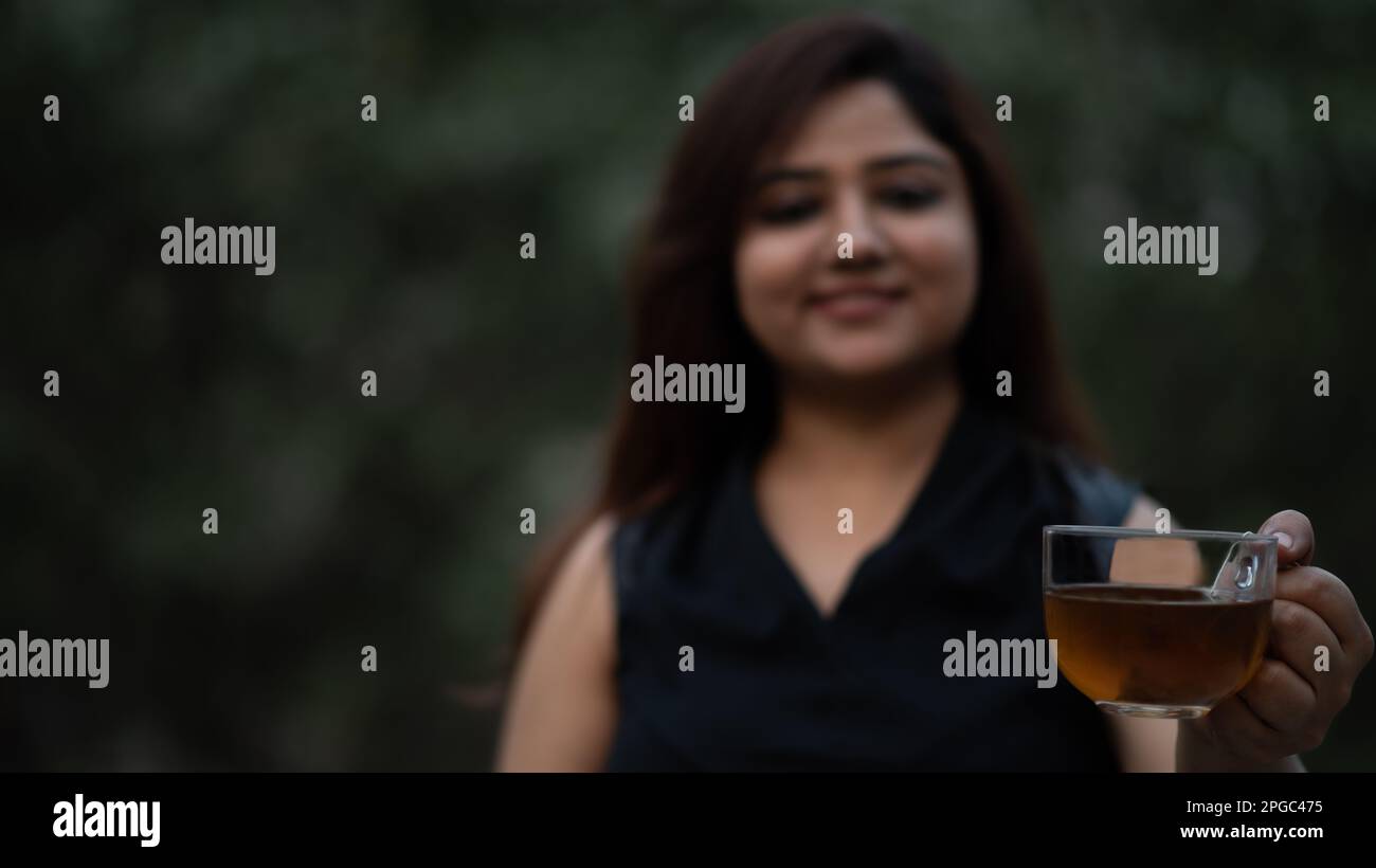 Frauen mit transparentem Glastee, die schwarzen Tee anbieten Stockfoto