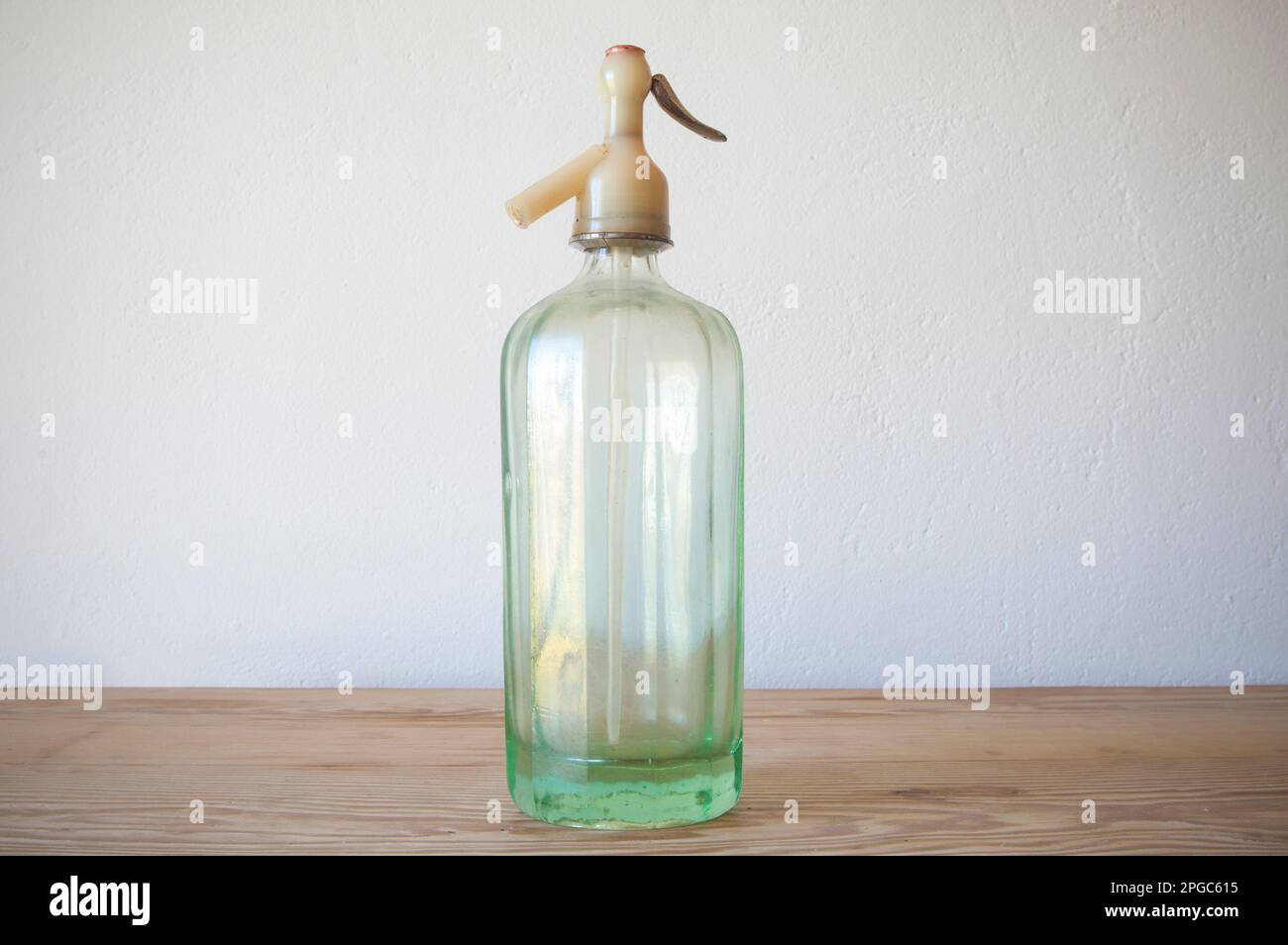 Ein alter Glas-Soda-Siphon. Holzfläche Stockfoto