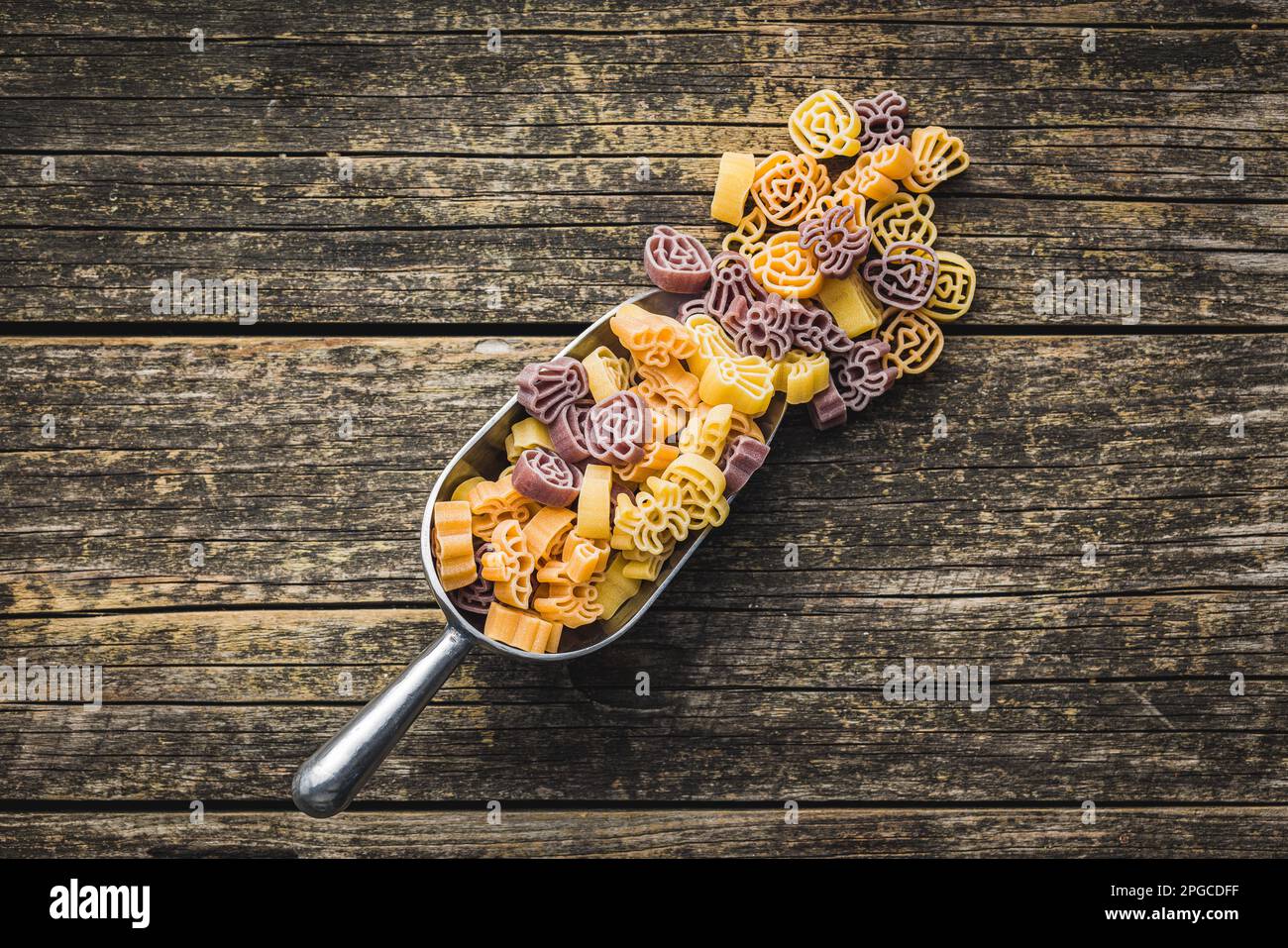 Pasta in verschiedenen unheimlichen Formen. Ungekochte halloween-Pasta in einer Schaufel auf dem Holztisch. Draufsicht. Stockfoto
