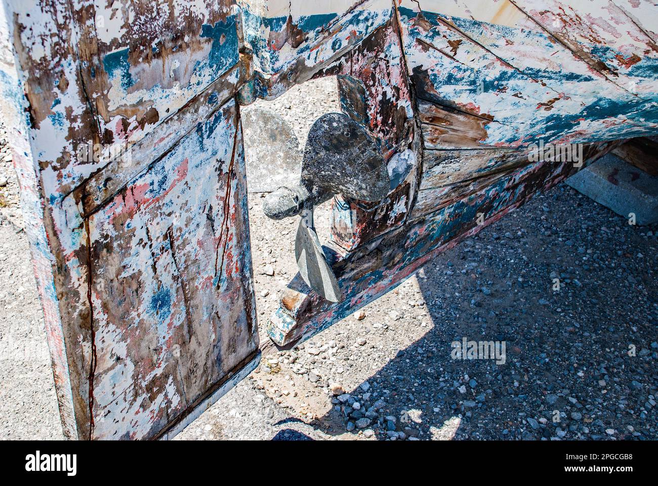 Farben und Texturen von abgeschabter Farbe auf der Unterseite eines gut abgenutzten Boots und auf seinem Ruder. Diese müden Exemplare ziehen die Aufmerksamkeit von Fotografen auf sich Stockfoto