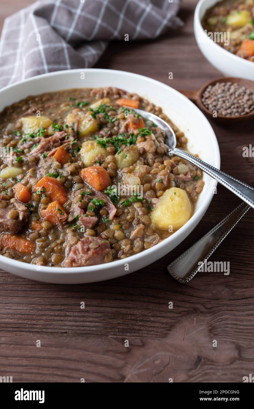 Eintopf mit Linsen, Schweinefleisch, Kartoffeln und Gemüse. Traditionelle deutsche Linsensuppe Stockfoto