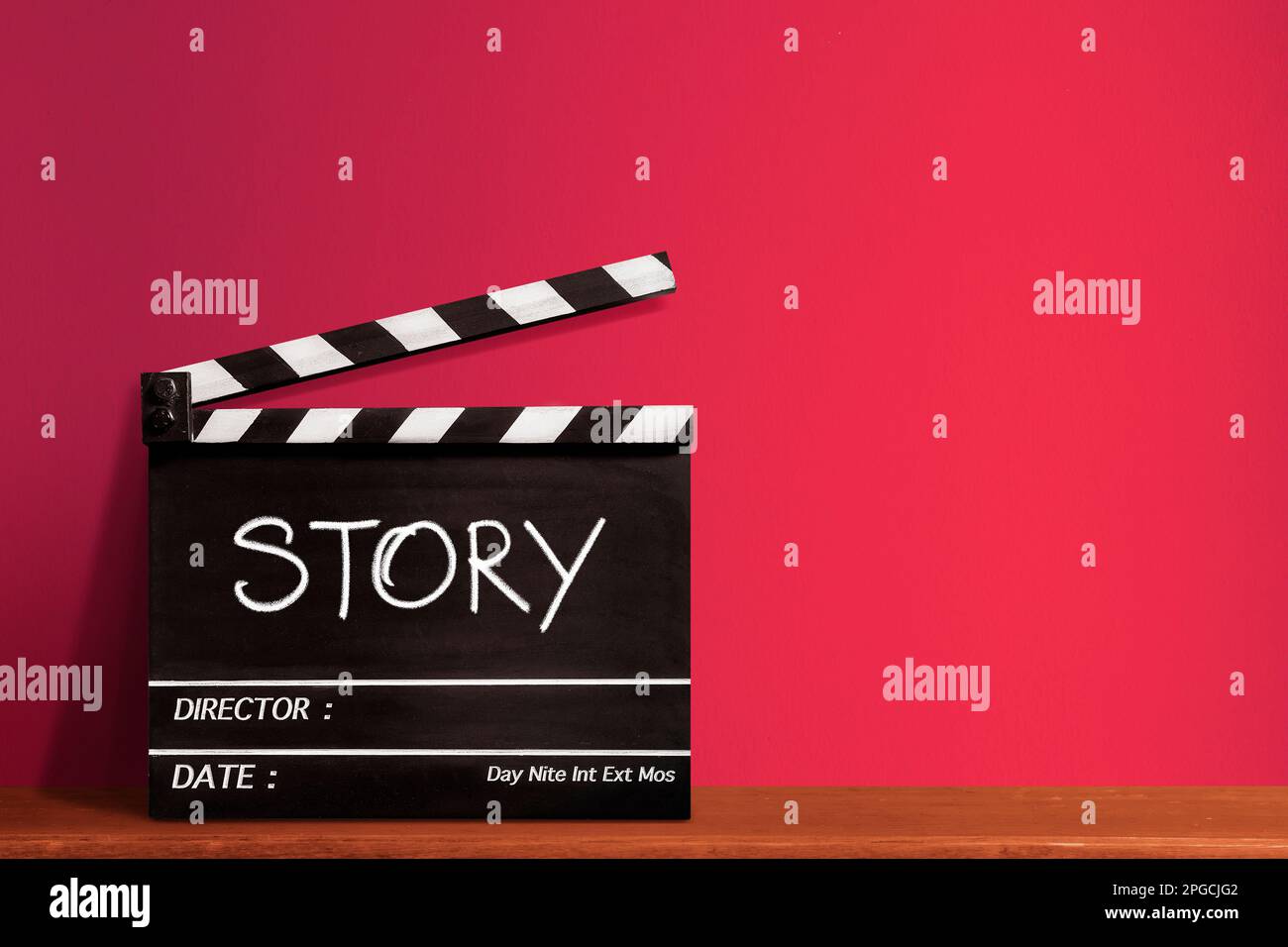 Geschichte, handgeschriebener Texttitel auf Filmschiefer für die Filmindustrie, roter Hintergrund. Stockfoto