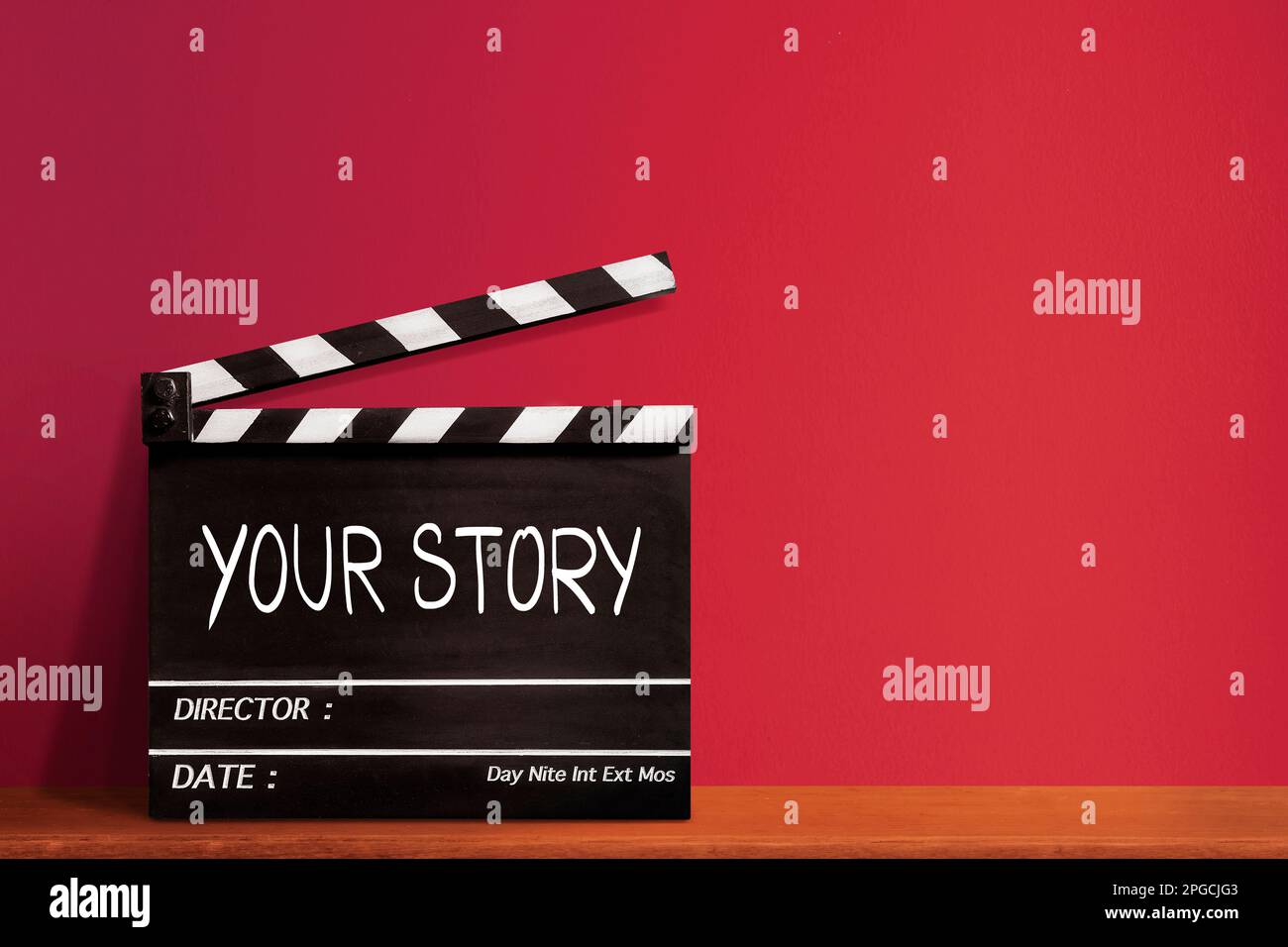 Ihre Geschichte, handgeschriebener Texttitel auf Filmschiefer für die Filmindustrie, roter Hintergrund. Stockfoto