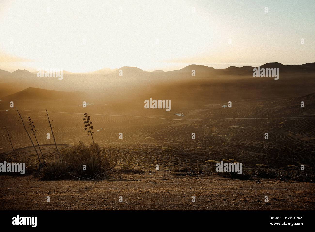 Malerische Landschaft mit trockenem wildem Gelände umgab meine Berge vor dem Sonnenuntergang am Himmel auf Lanzarote Stockfoto