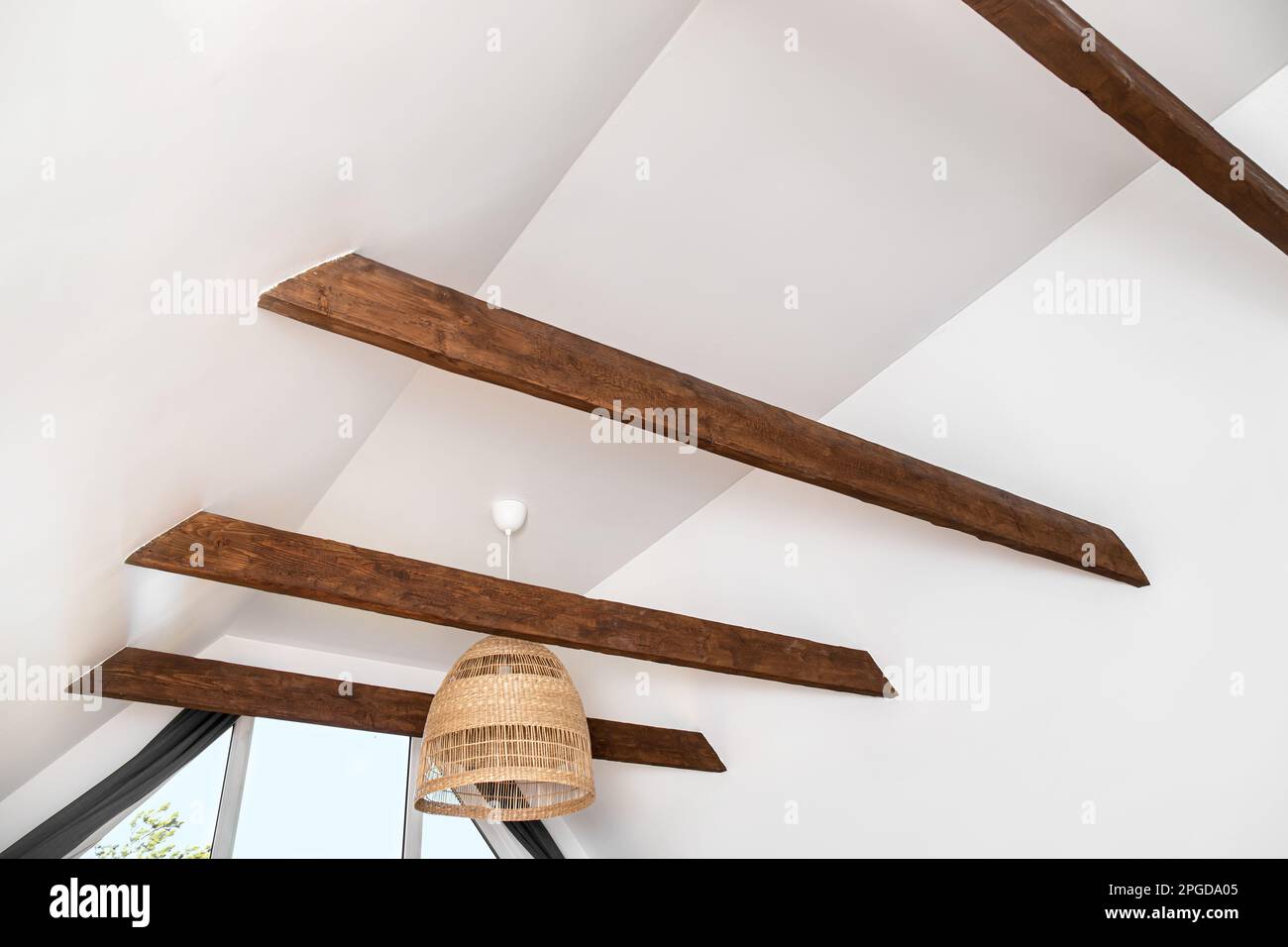Braune dekorative Holzbalken in der weißen Decke des Wohnzimmers. Hübsche, moderne kontrastreiche Akzente. Stockfoto