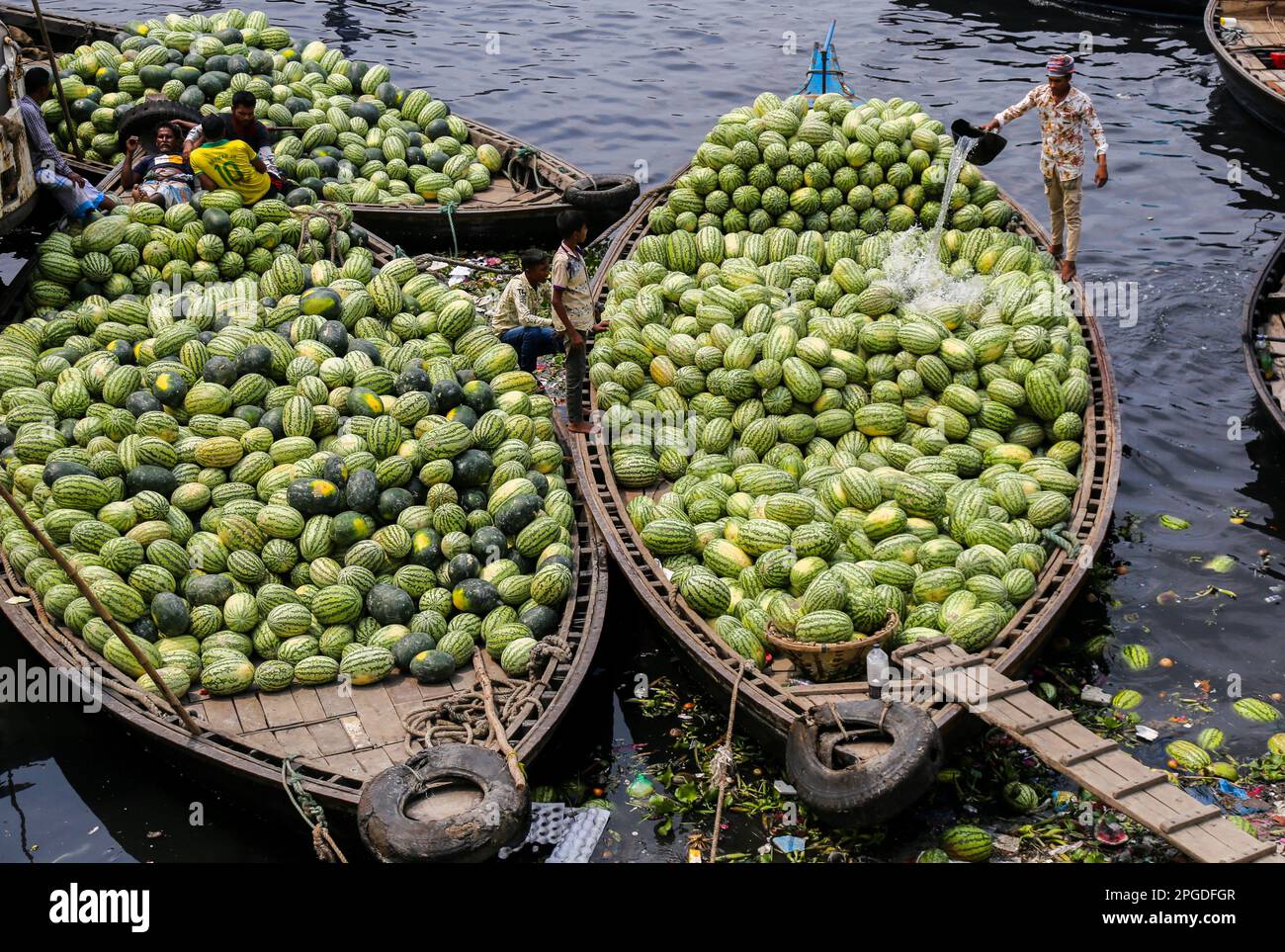 Dhaka, Bangladesch. 21. März 2023. Arbeiter entladen Wassermelonen von den Booten in Sadarghat, um sie in Dhaka zu verkaufen. In Bangladesch in dieser Saison eine erstklassige Produktion von Wassermelonen. Experten haben gesagt, dass die gute Qualität der Wassermelonen in diesem Jahr aufgrund des günstigen Wetters und der verbesserten Landwirtschaft eine hervorragende Ernte war. (Foto: Rayhan Ahmed/Pacific Press) Kredit: Pacific Press Media Production Corp./Alamy Live News Stockfoto