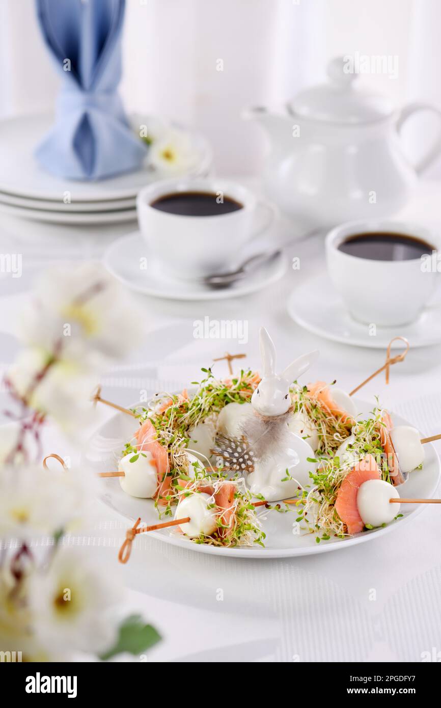 Vorspeise Wachtelei gefüllt mit Luzerne Sprossen mit einer Scheibe Lachs, auf einem Holzspieß. Buffet für den Ostertisch. Stockfoto