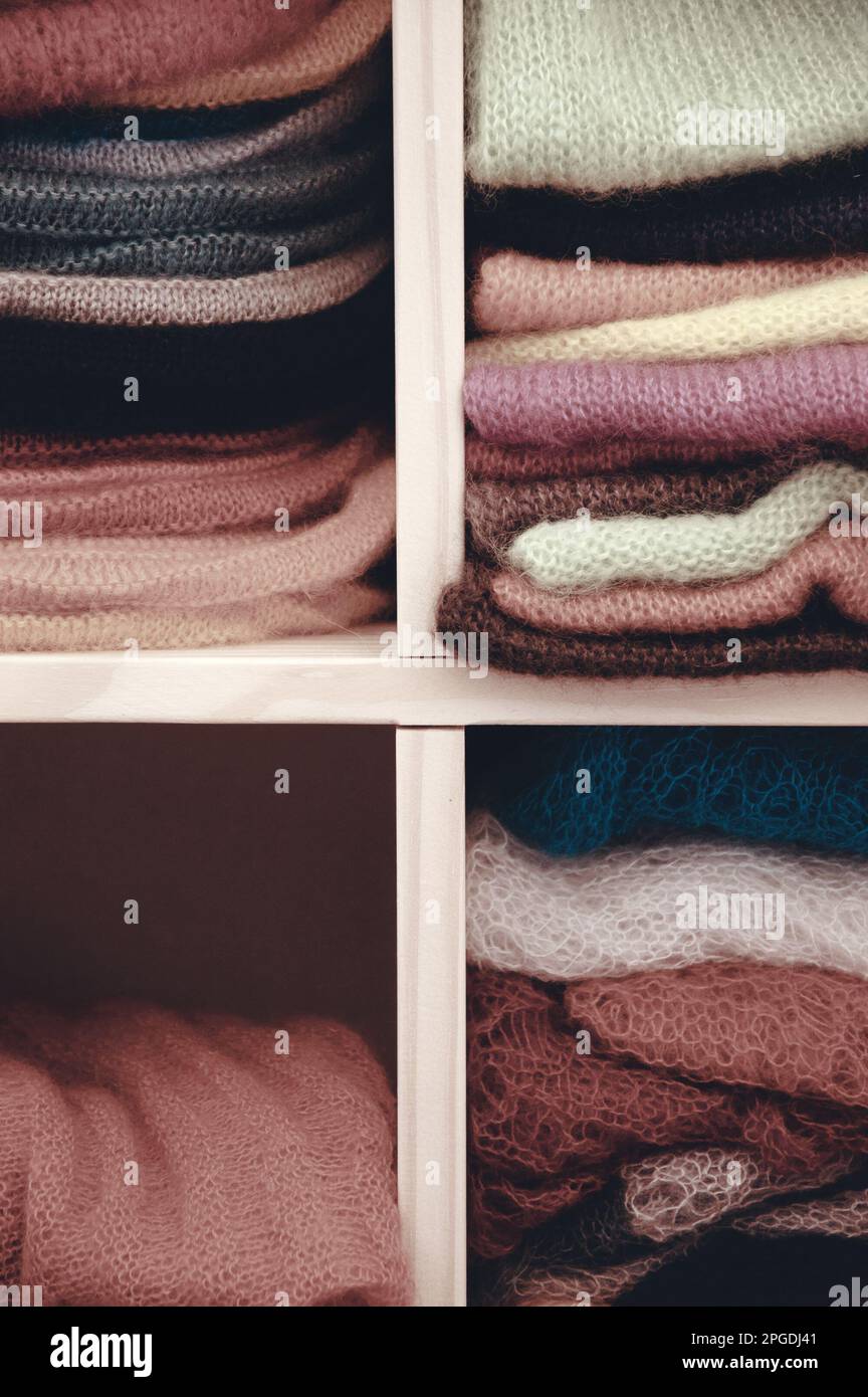 Ein Stapel bunter Strickkleidung - Pullover, Kleider, Strickjacken usw. Stockfoto