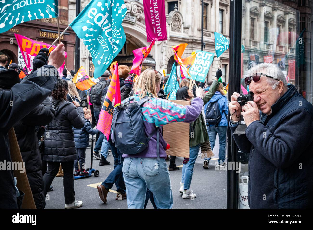 London, Großbritannien. 15. März 2023. Der ältere Mann spricht Bilder, während Protest vorbei ist. Demonstranten bei der größten Demonstration seit Beginn der Streiks. Der "Budget Day"-Protest im Zentrum von London. Tausende marschierten durch die Straßen in Richtung Trafalgar Square, darunter Lehrer, Ärzte in der Ausbildung und Beamte, die sich alle um bessere Bezahlung und Arbeitsbedingungen bemühten. Insgesamt haben rund eine halbe Million Beschäftigte im öffentlichen Dienst im ganzen Land zu viel bezahlt. Stockfoto