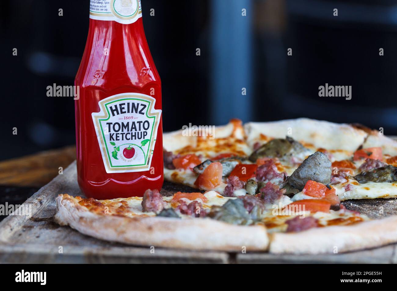 Heinz Ketchup und rustikale Pizza auf dem Holztisch Stockfoto