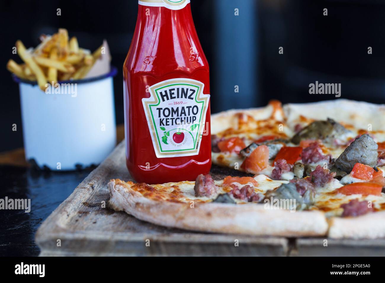 Heinz Ketchup und rustikale Pizza auf dem Holztisch Stockfoto