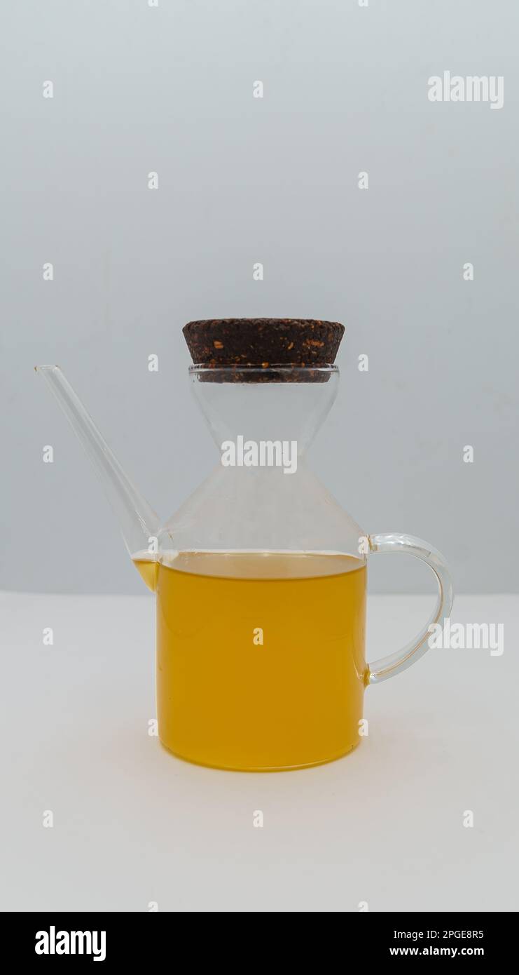 Ungefiltertes natives Olivenöl extra in einer kleinen Glasflasche, isoliert auf weißem Hintergrund und Nahaufnahme. Stockfoto