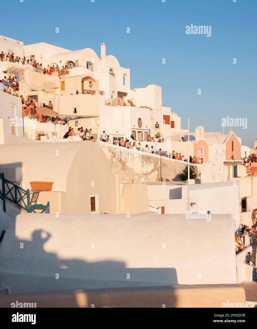 Traditioneller Brauch im Dorf Oia in Griechenland, den jeder auf den Dächern von Häusern in einem Moment der Entspannung und Zusammengehörigkeit zu bewundern versammelt Stockfoto