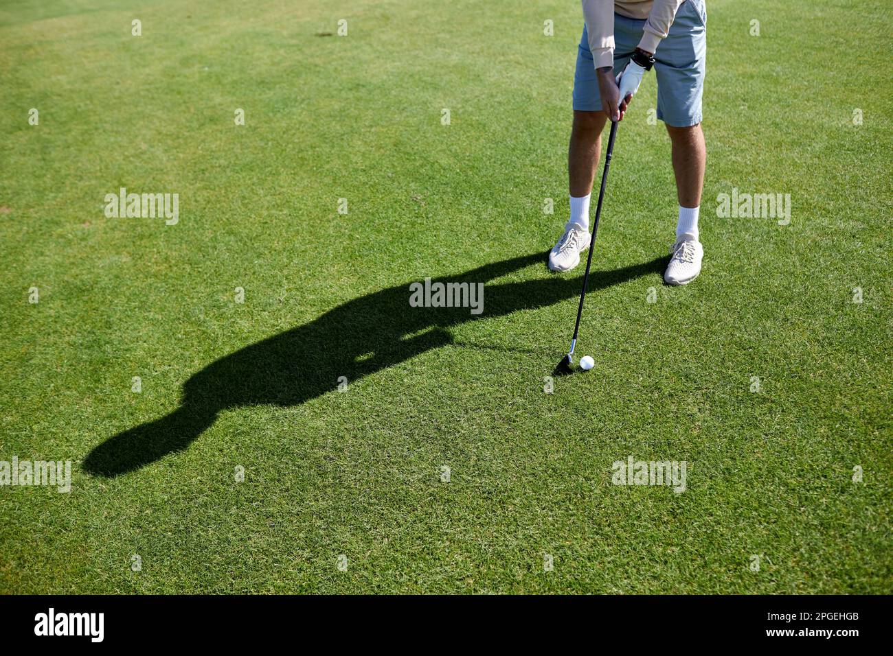 Unterer Teil eines unbekannten Mannes, der Golf auf grünem Gras spielt und auf perfekte Schüsse, Kopierraum zielt Stockfoto