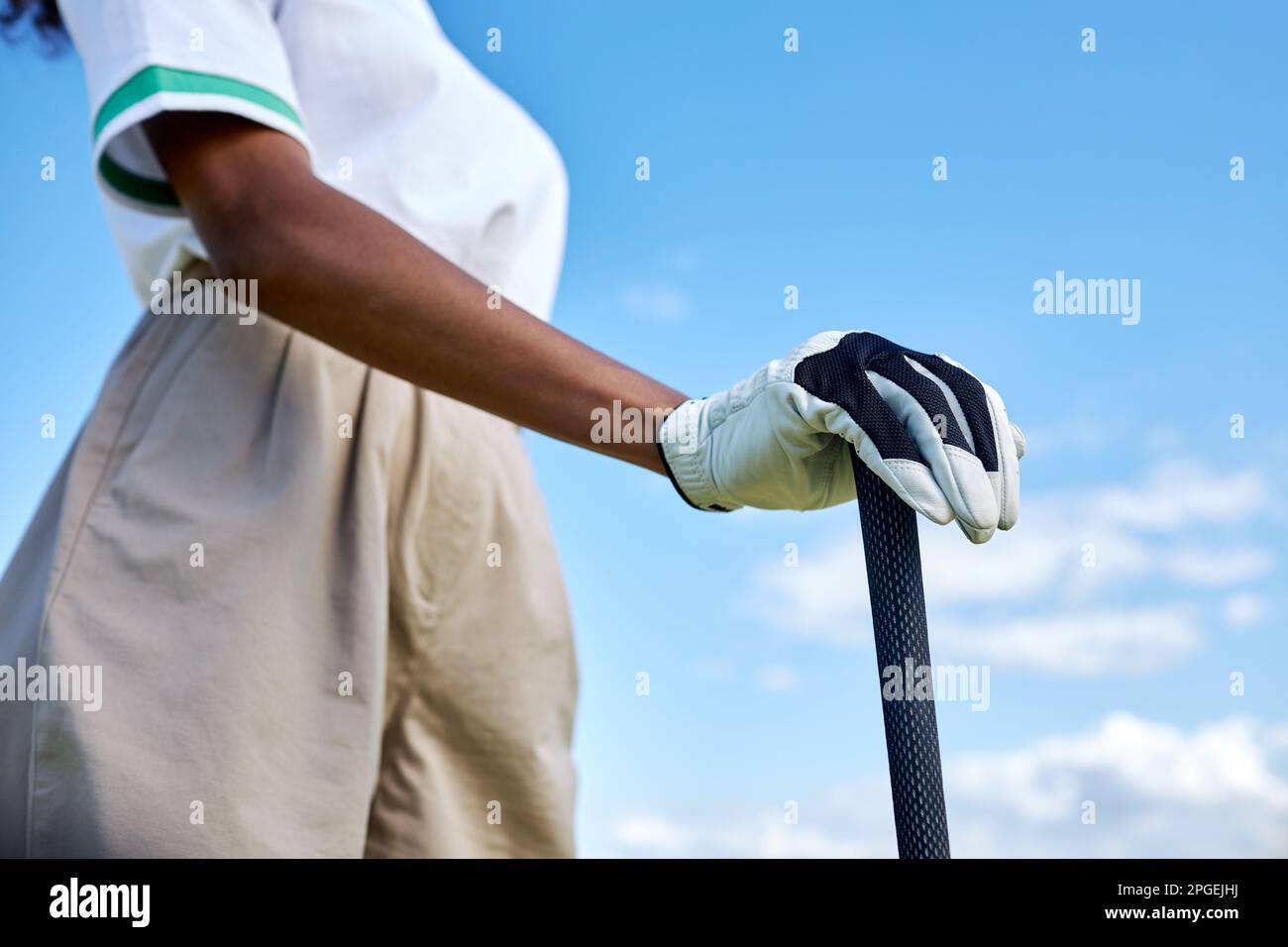 Nahaufnahme einer weiblichen Hand, die im Freien einen Golfschläger gegen den blauen Himmel hält, Kopierraum Stockfoto
