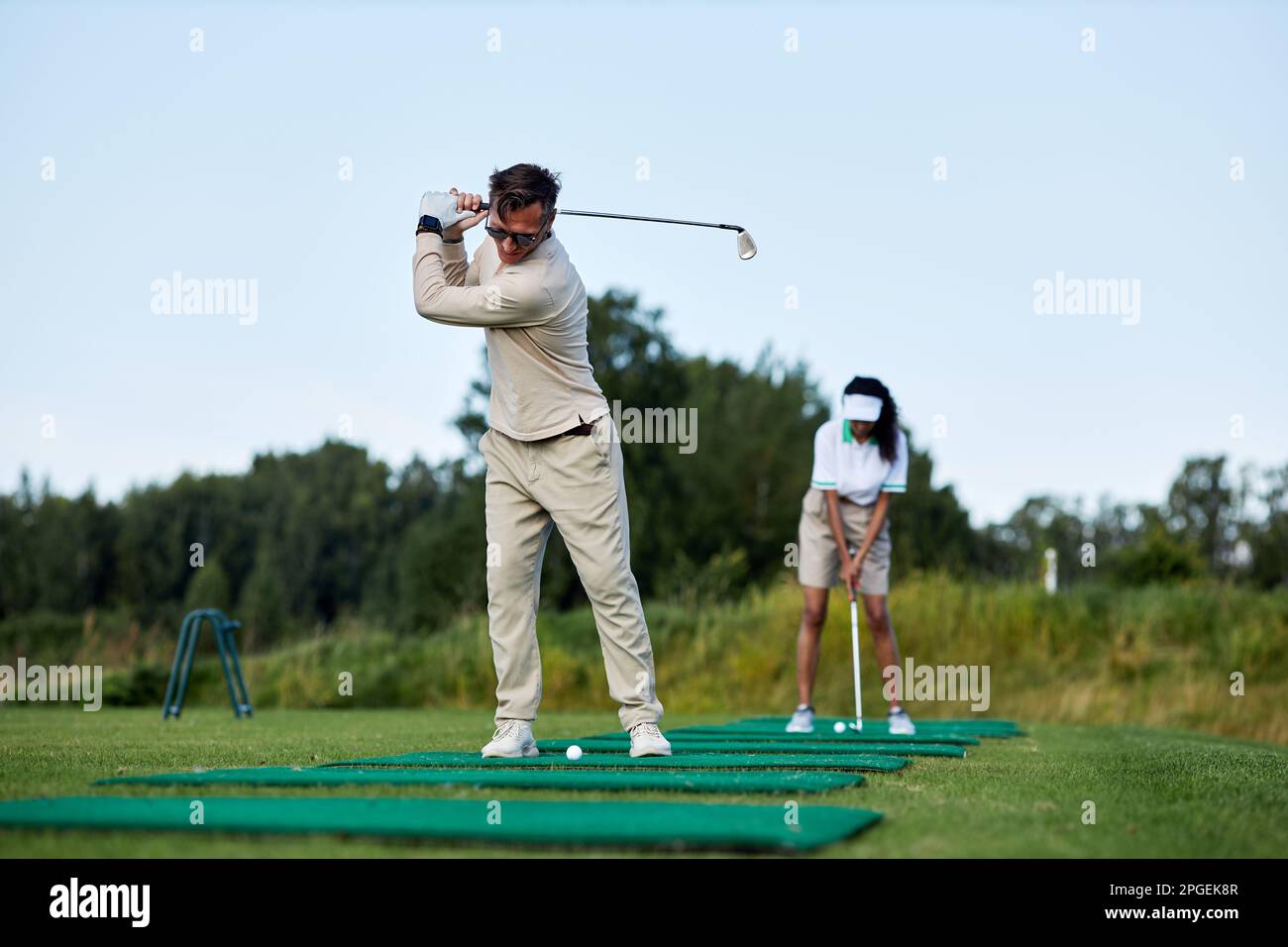 Porträt des sportlichen Mannes, der im Freien Golf spielt, und des Schaukelclubs, während er auf der Plattform steht Stockfoto