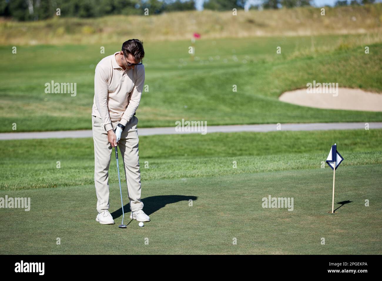 Porträt eines erwachsenen weißen Mannes, der Golf auf grünem Gras spielt, Kopierbereich Stockfoto