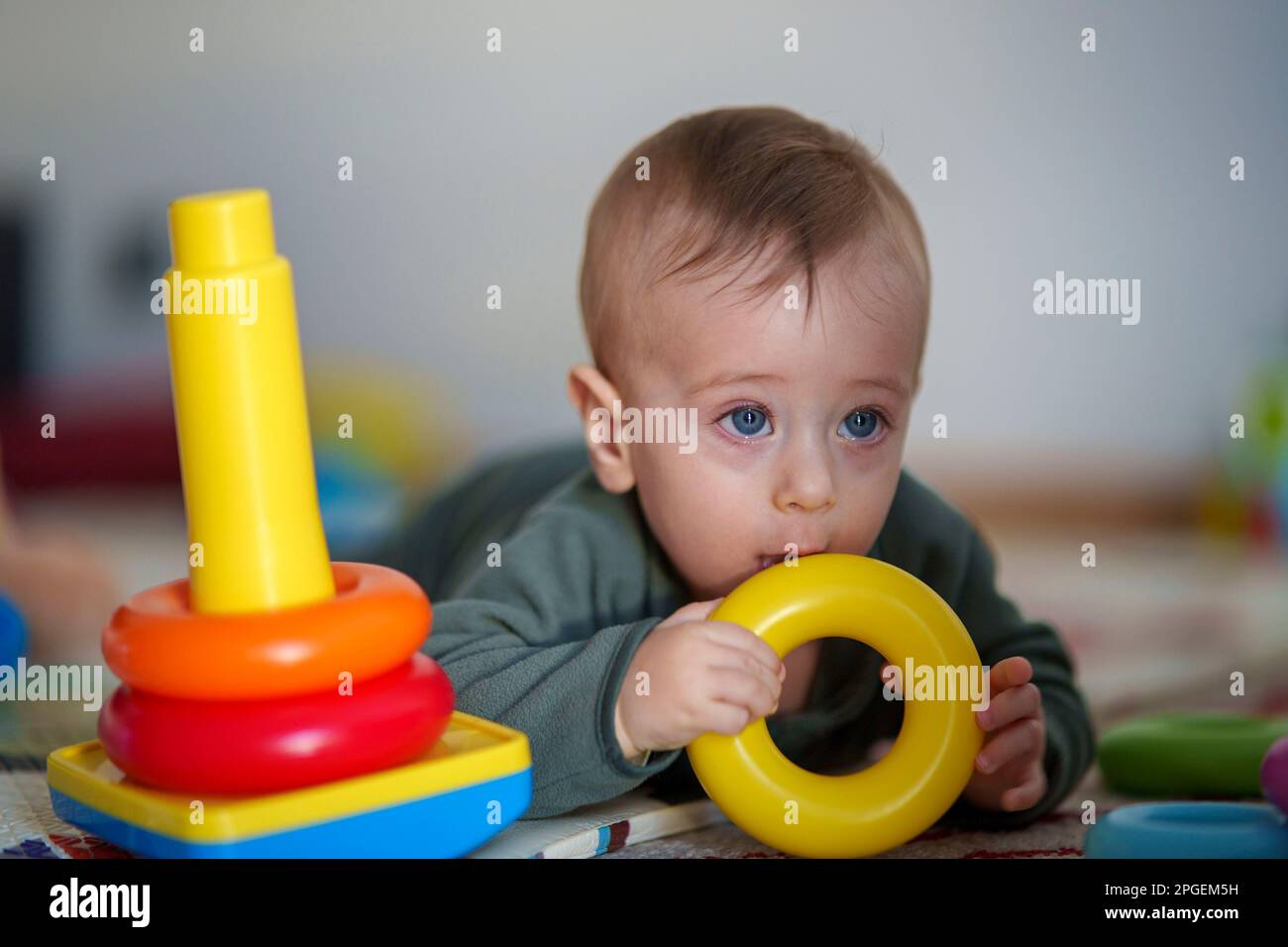 Ihr Baby spielt mit bunten, stapelbaren Ringen Stockfoto