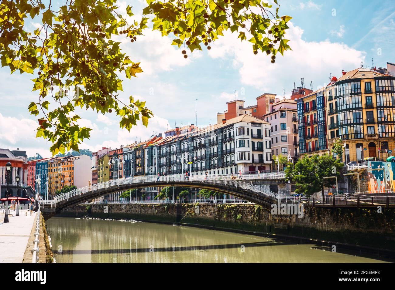 Blick auf die Innenstadt von Bilbao mit dem Fluss Nervion, der Ribera-Brücke und seiner farbenfrohen Architektur an einem sonnigen Tag. Ich genieße einen schönen Urlaub im Stockfoto