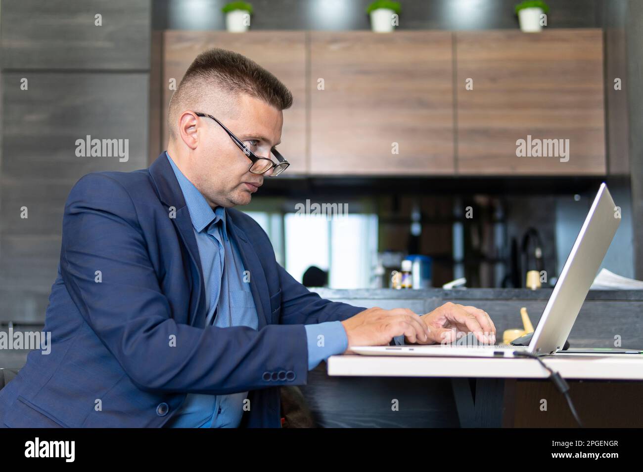 Mann sitzt am Schreibtisch und arbeitet von zu Hause aus mit einem Laptop. Ein Mitarbeiter mit Außendienst ist freiberuflich tätig. Unternehmensberater. Stockfoto