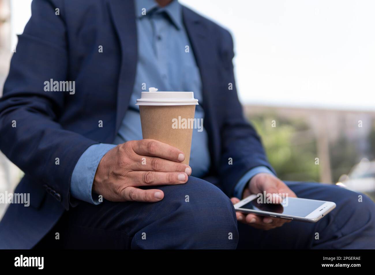 Business, Education, Technology, Communication and People Concept – kreativer Mann mit Smartphone, der Kaffee aus dem Pappbecher trinkt und auf der City St. Stockfoto