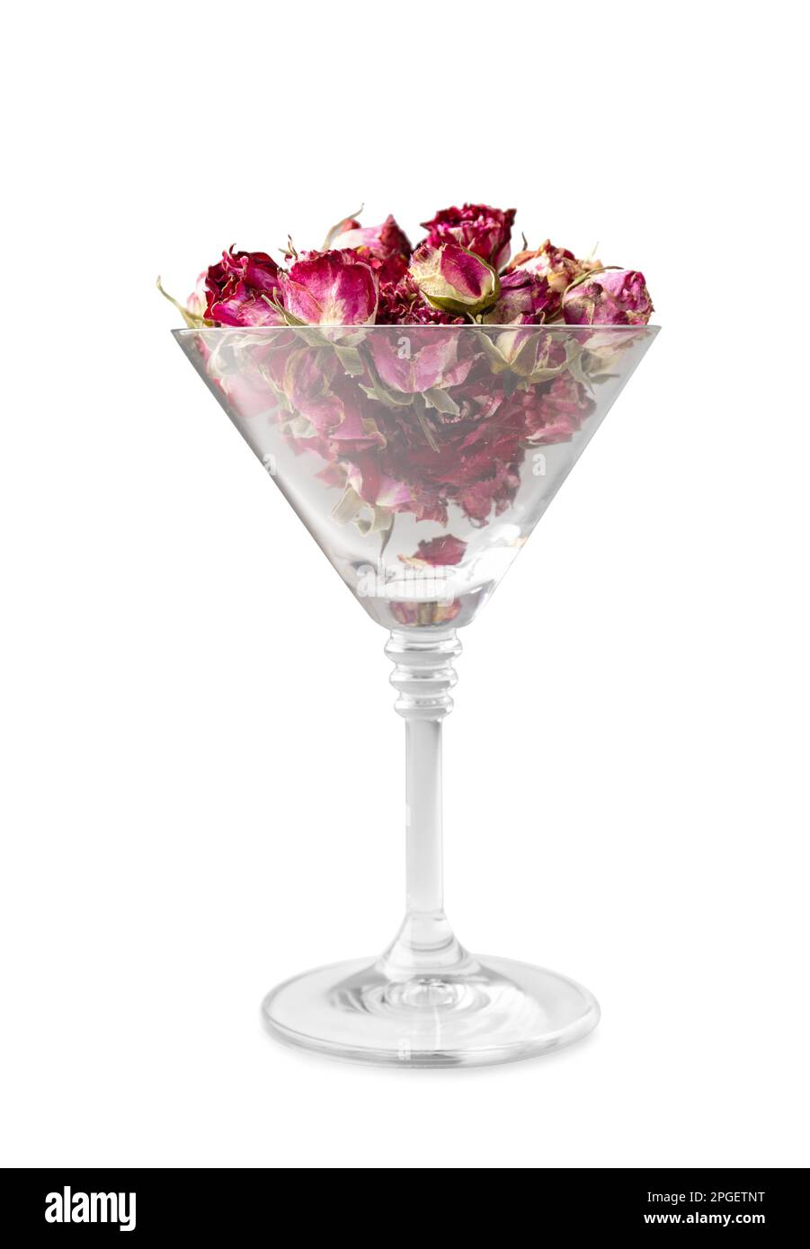 Knospen rosafarbener Rosen in einem isolierten martini-Glas. Knospen getrockneter Blüten in einem Glasbecher auf weißem Hintergrund. Getrockneter Blumentee. Valentinstag. Stockfoto