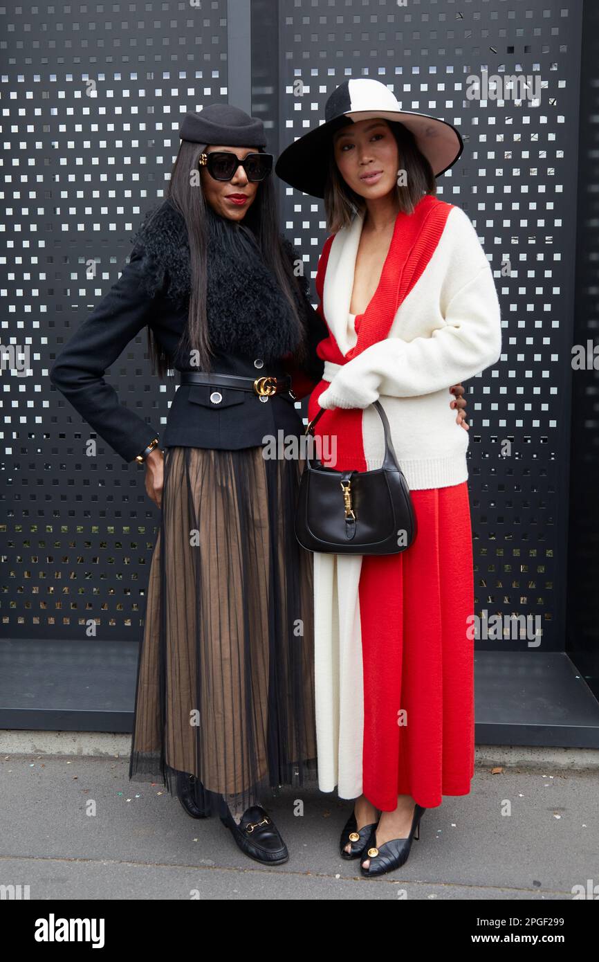 MAILAND, ITALIEN - 24. FEBRUAR 2023: Frauen mit schwarzer Jacke und rot-weißer Jacke und Rock vor der Gucci-Modenschau, Mailand Fashion Week Street Style Stockfoto