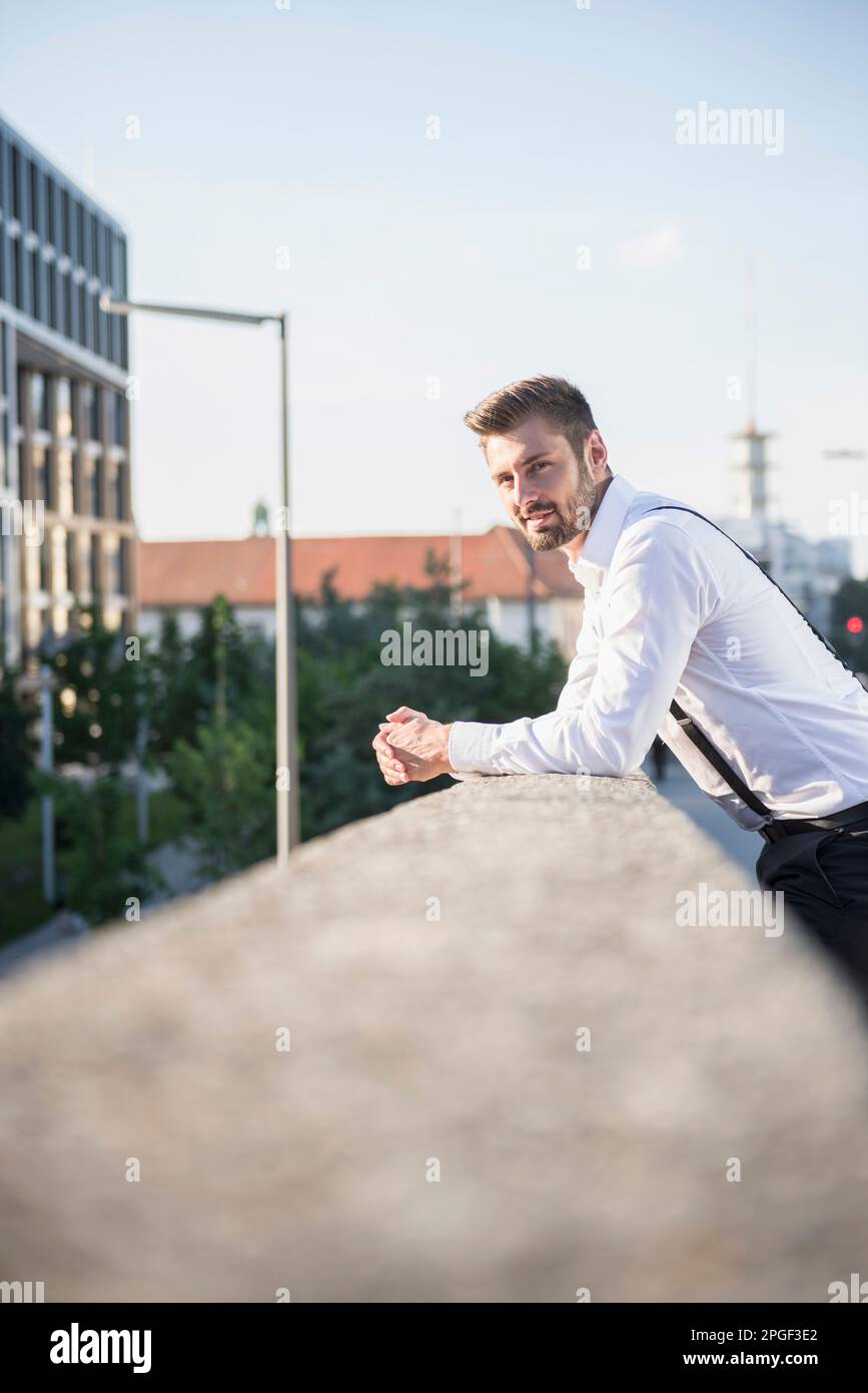 Porträt eines Geschäftsmannes, der sich gegen das Geländer lehnt, München, Bayern, Deutschland Stockfoto