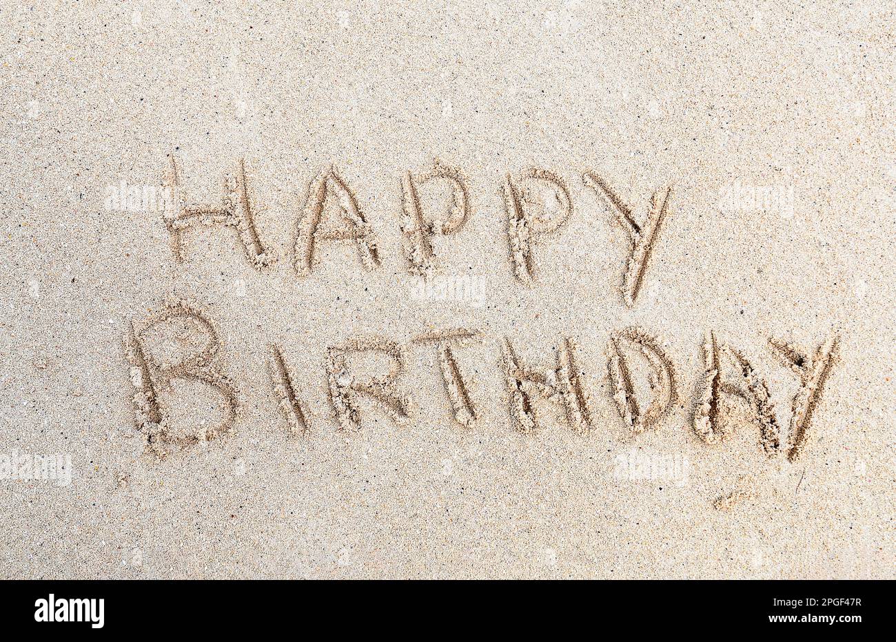 „Happy Birthday“-Text gedruckt in Beach Sand Stockfoto