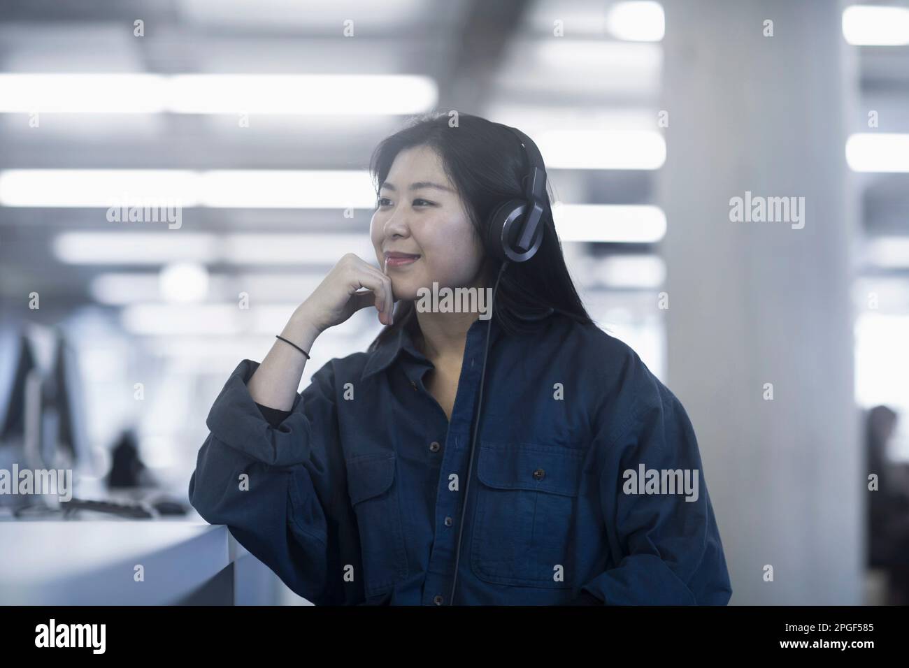 Geschäftsfrau, die mit Kopfhörern Musik hört, Freiburg im Breisgau, Baden-Württemberg, Deutschland Stockfoto