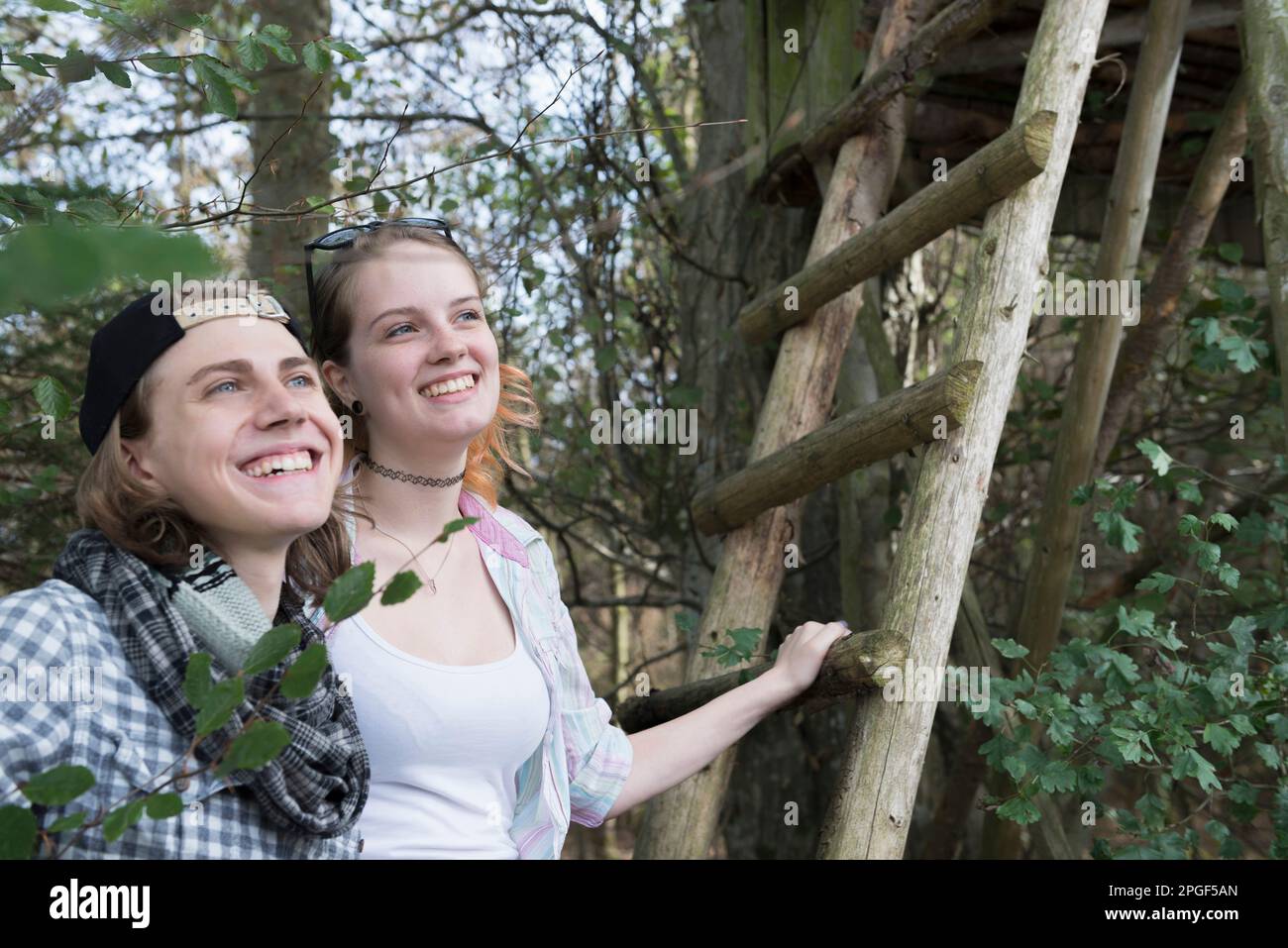 Nahaufnahme eines jungen Paares, das mit einer Leiter aus Aussichtsturm und Lächeln steht, Bayern, Deutschland Stockfoto
