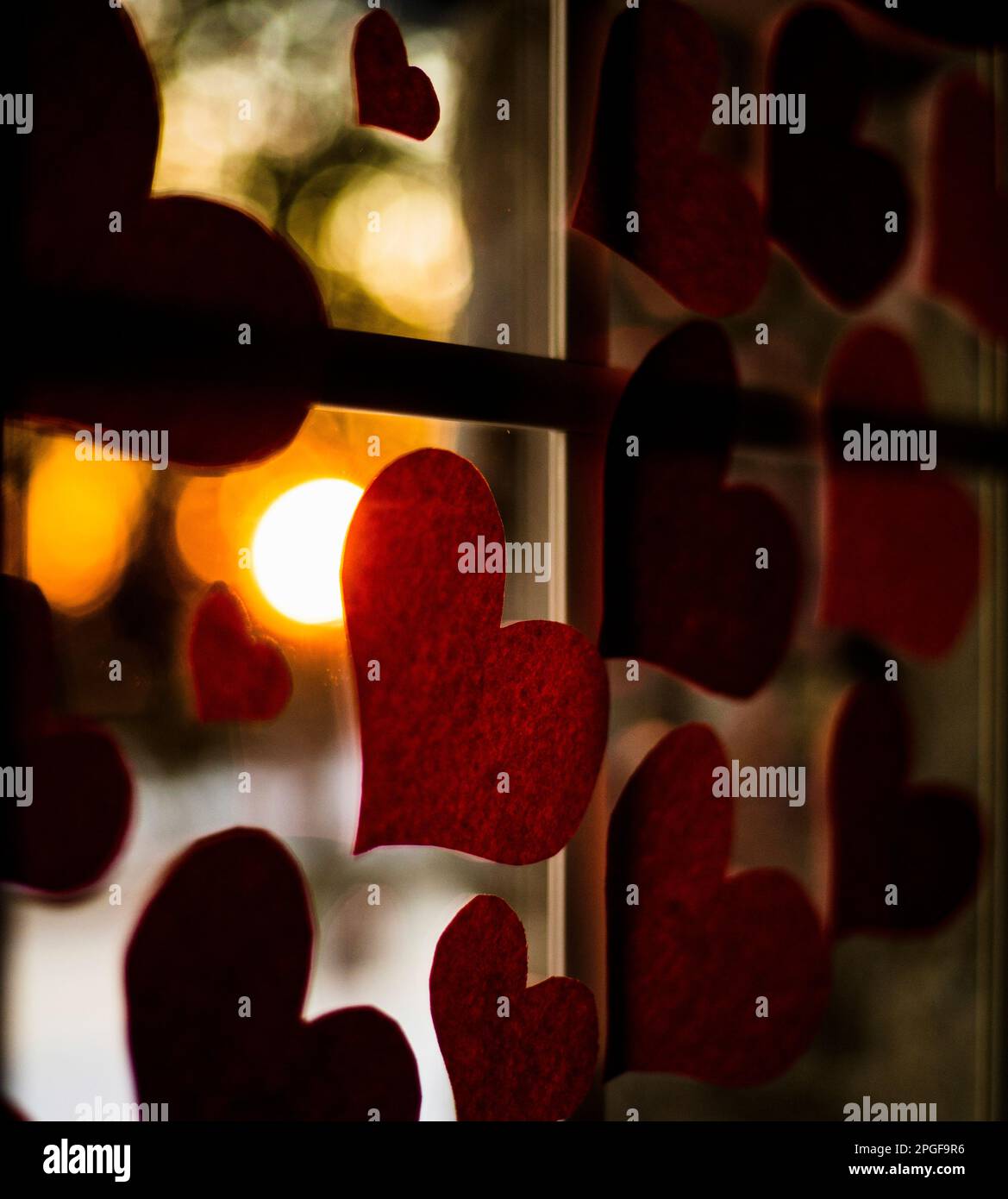 Liebe Herz im Fenster mit Sonnenuntergang im Hintergrund Stockfoto