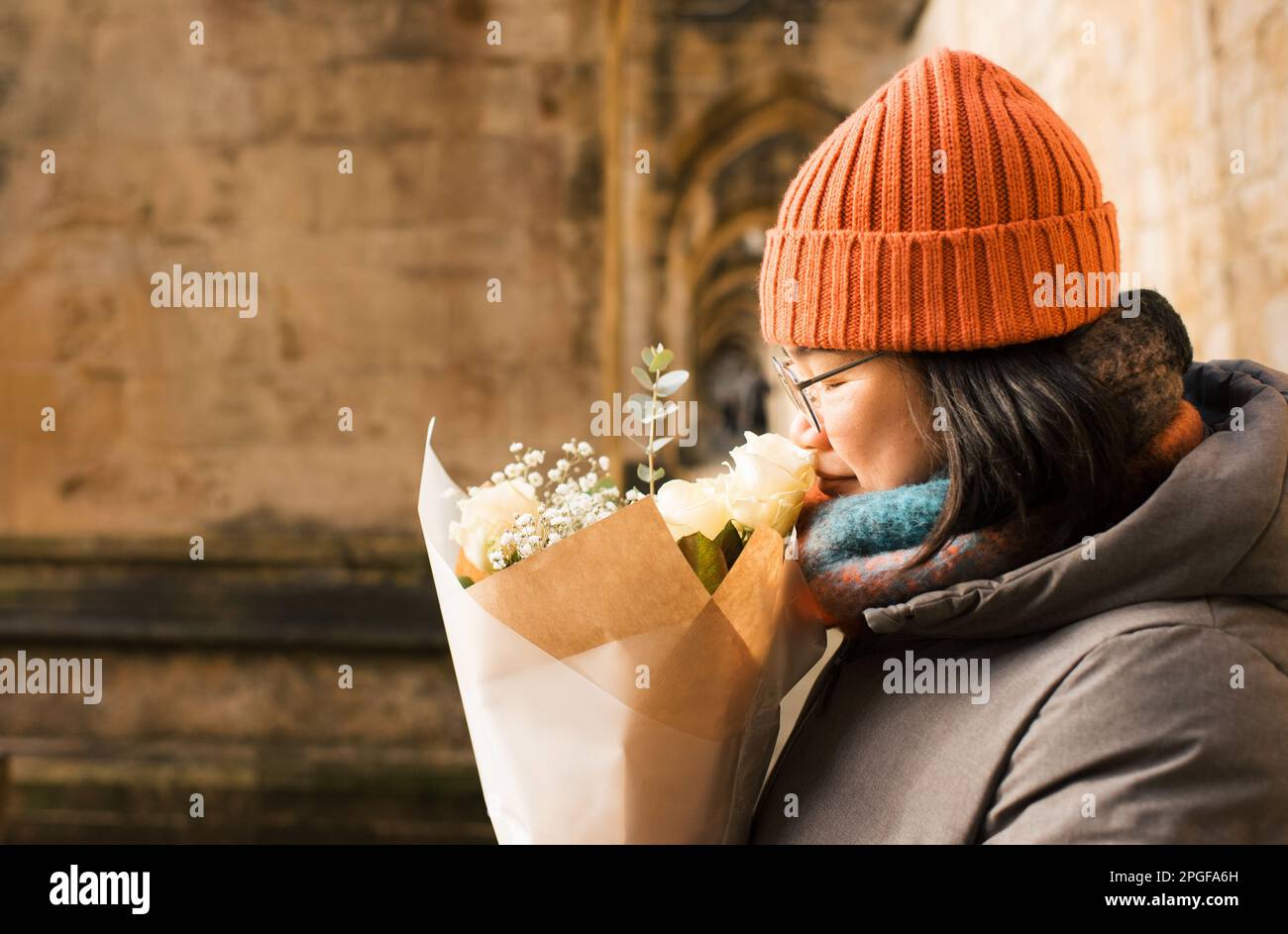 Asiatische Frau, die einen Blumenstrauß riecht Stockfoto