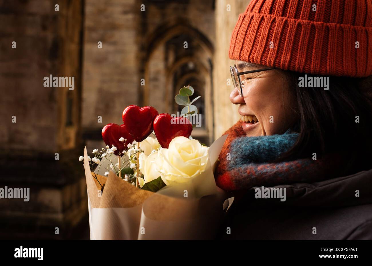 Porträt einer Frau, die einen Blumenstrauß mit roten Herzen hält Stockfoto