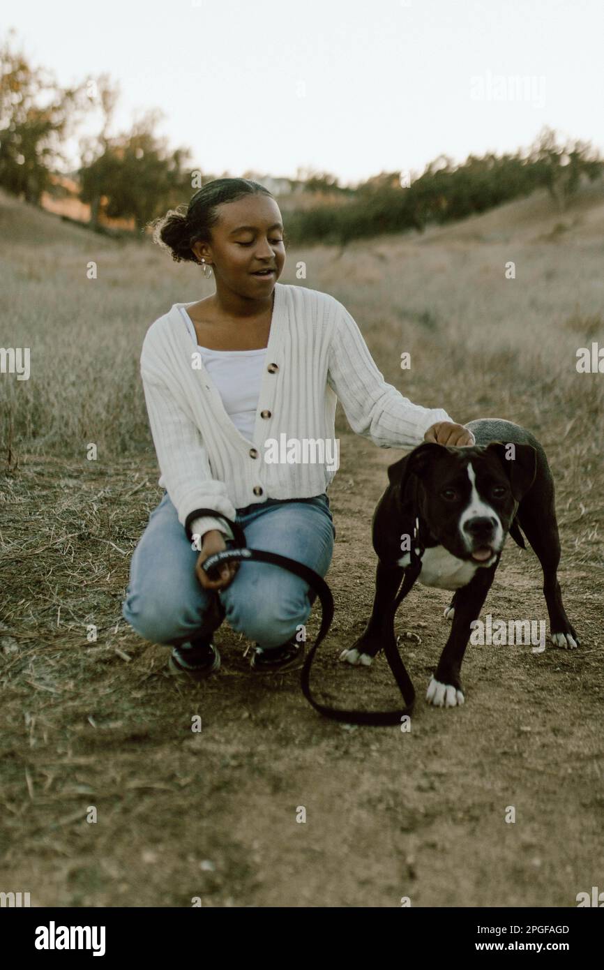 Ein Mädchen auf einem Feld mit ihrem Hund Stockfoto