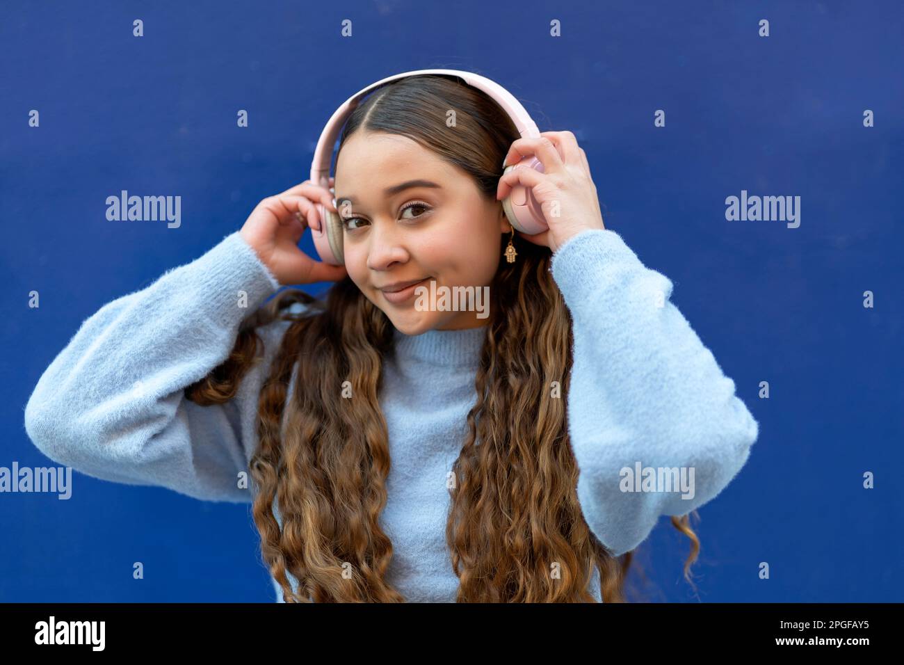 Ein junges Mädchen, das ihre Kopfhörer benutzt Stockfoto