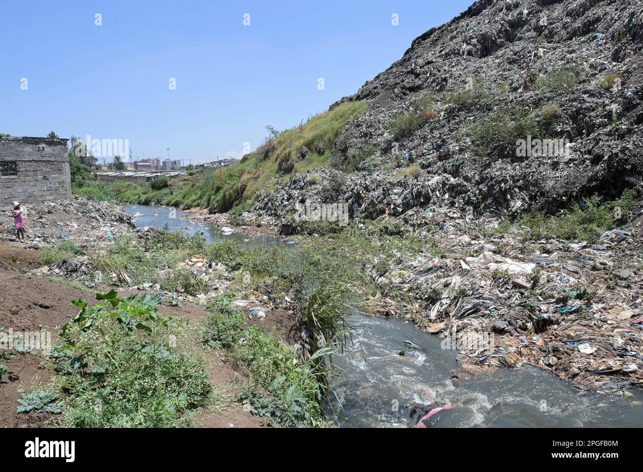 KENIA, Nairobi, Korogocho Slum, Dandora Mülldeponie, Schmutzwasser im Kanalisationskanal, Plastikmüll / KENIA, Nairobi, Korogocho Slum, Dandora Müllkippe Stockfoto