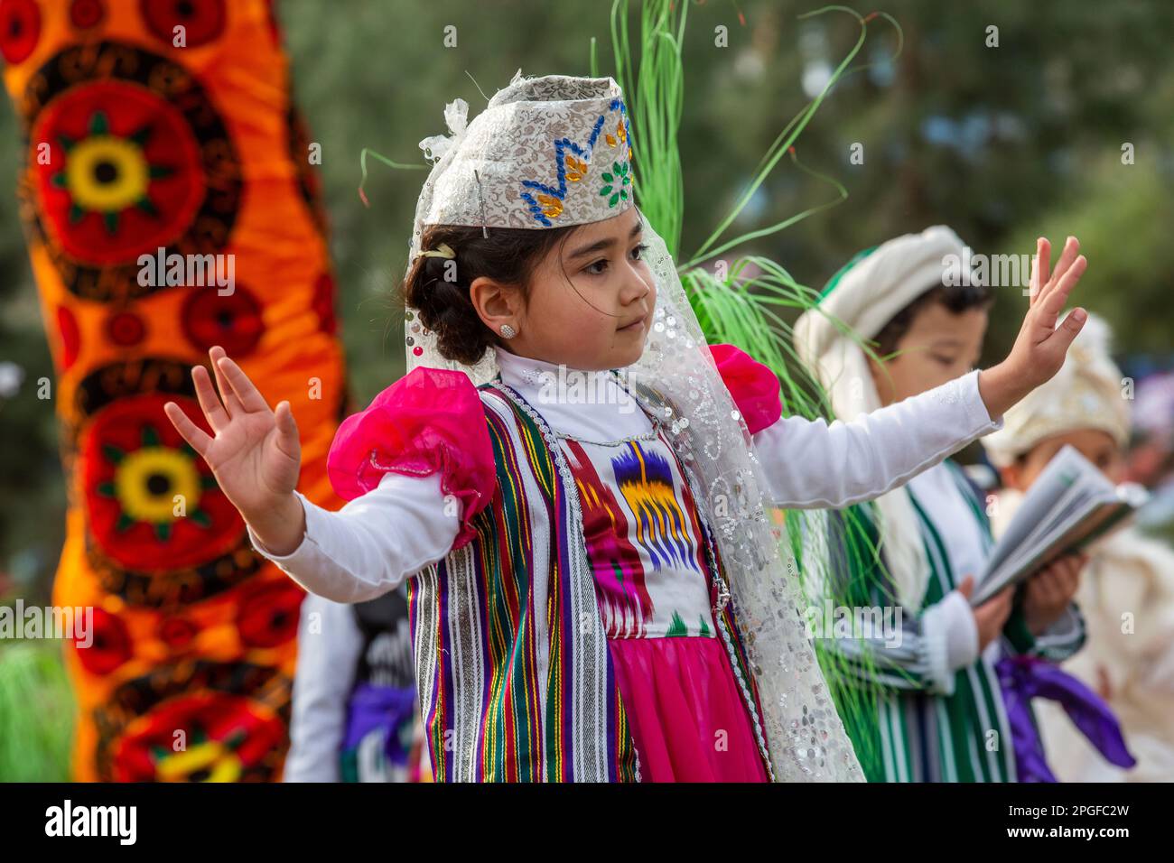 Stadt Khujand, Tadschikistan. 21. März 2015. Ein kleines Mädchen tanzt in einem Nationalkostüm auf einer Bühne während der Feiertage in Navruz im Navruzgoh Park in Khujand, Tadschikistan Republik Stockfoto