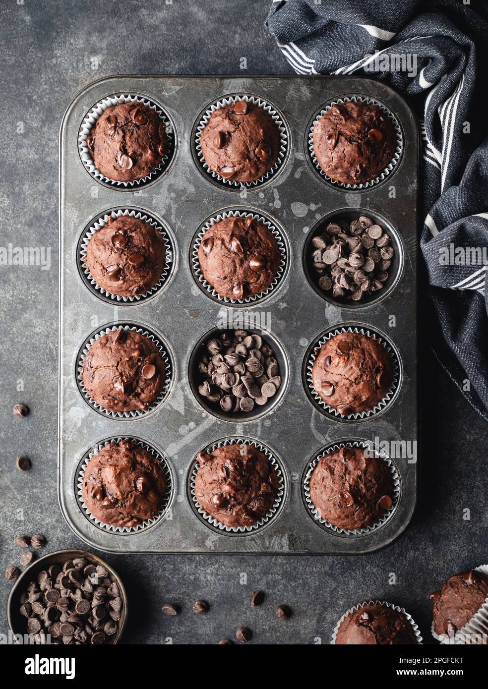 Über dem Kopf eine Dose Schokoladenzucchini-Muffins auf schwarzem Hintergrund. Stockfoto