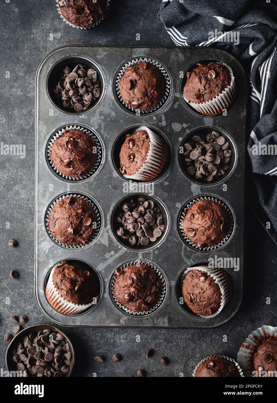Über dem Kopf eine Dose Schokoladenzucchini-Muffins auf schwarzem Hintergrund. Stockfoto