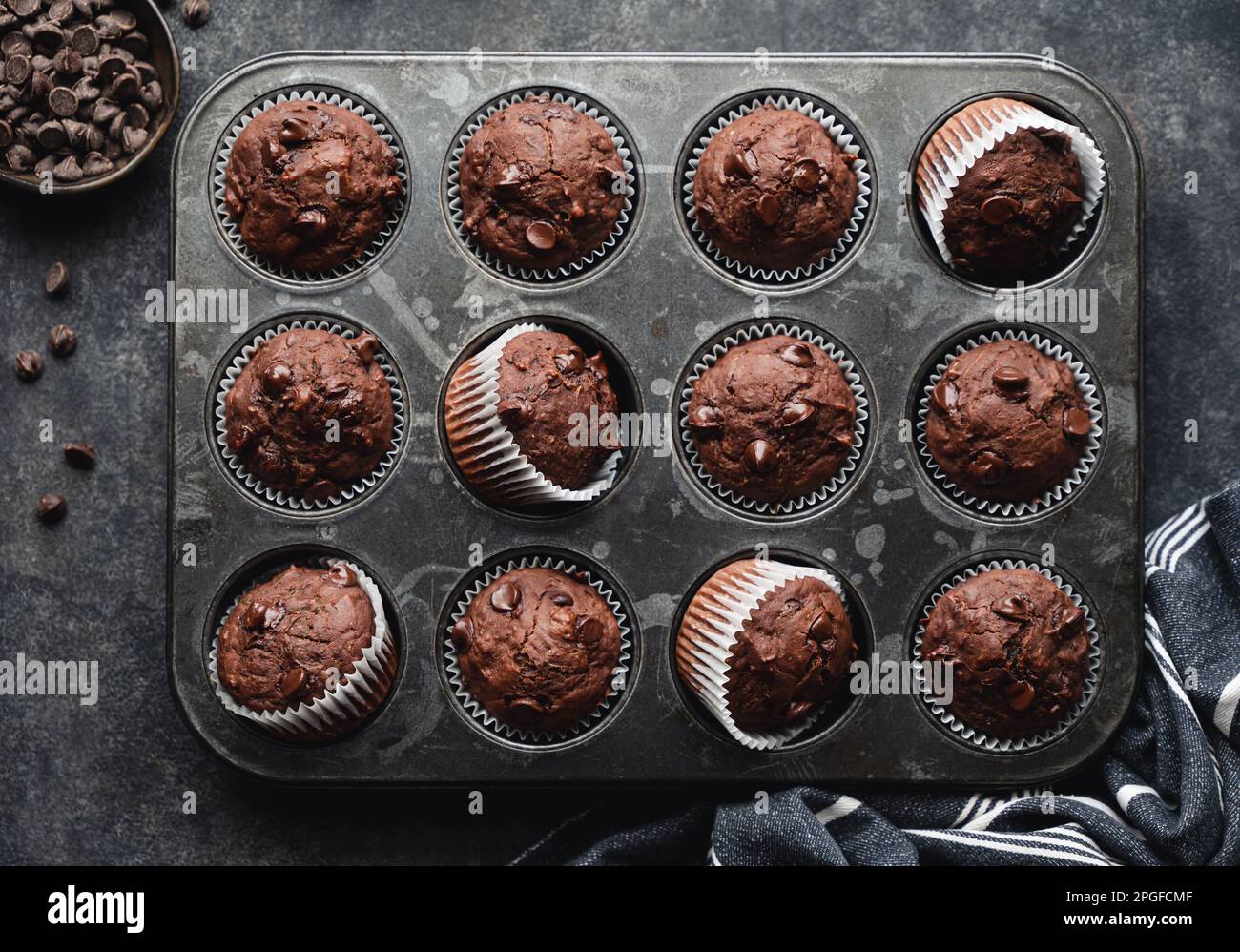 Über dem Kopf eine Dose Schokoladenzucchini-Muffins auf schwarzem Hintergrund. Stockfoto