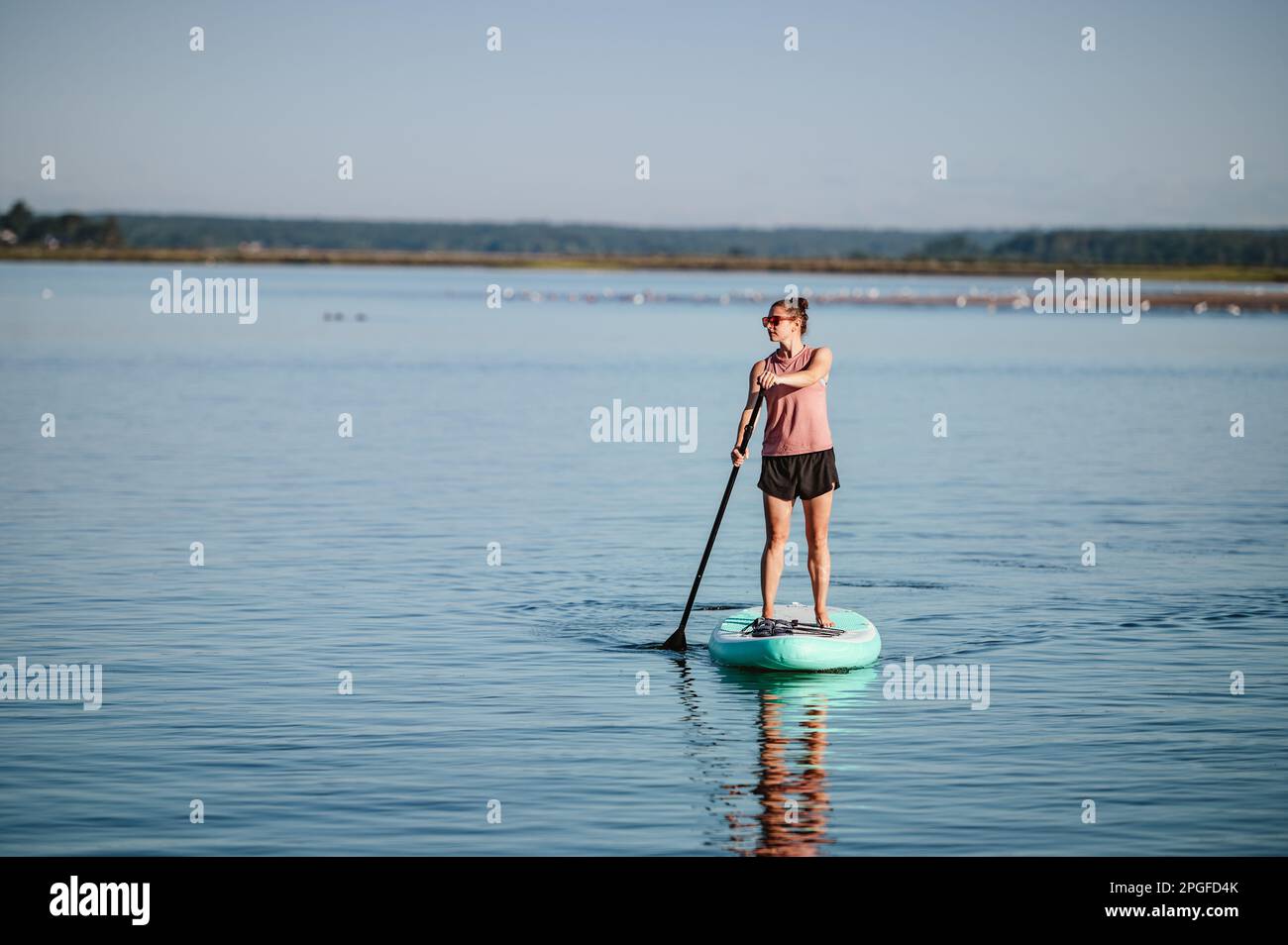 Frau auf Stand-up-Paddleboard auf dem Meer im Sommer Stockfoto