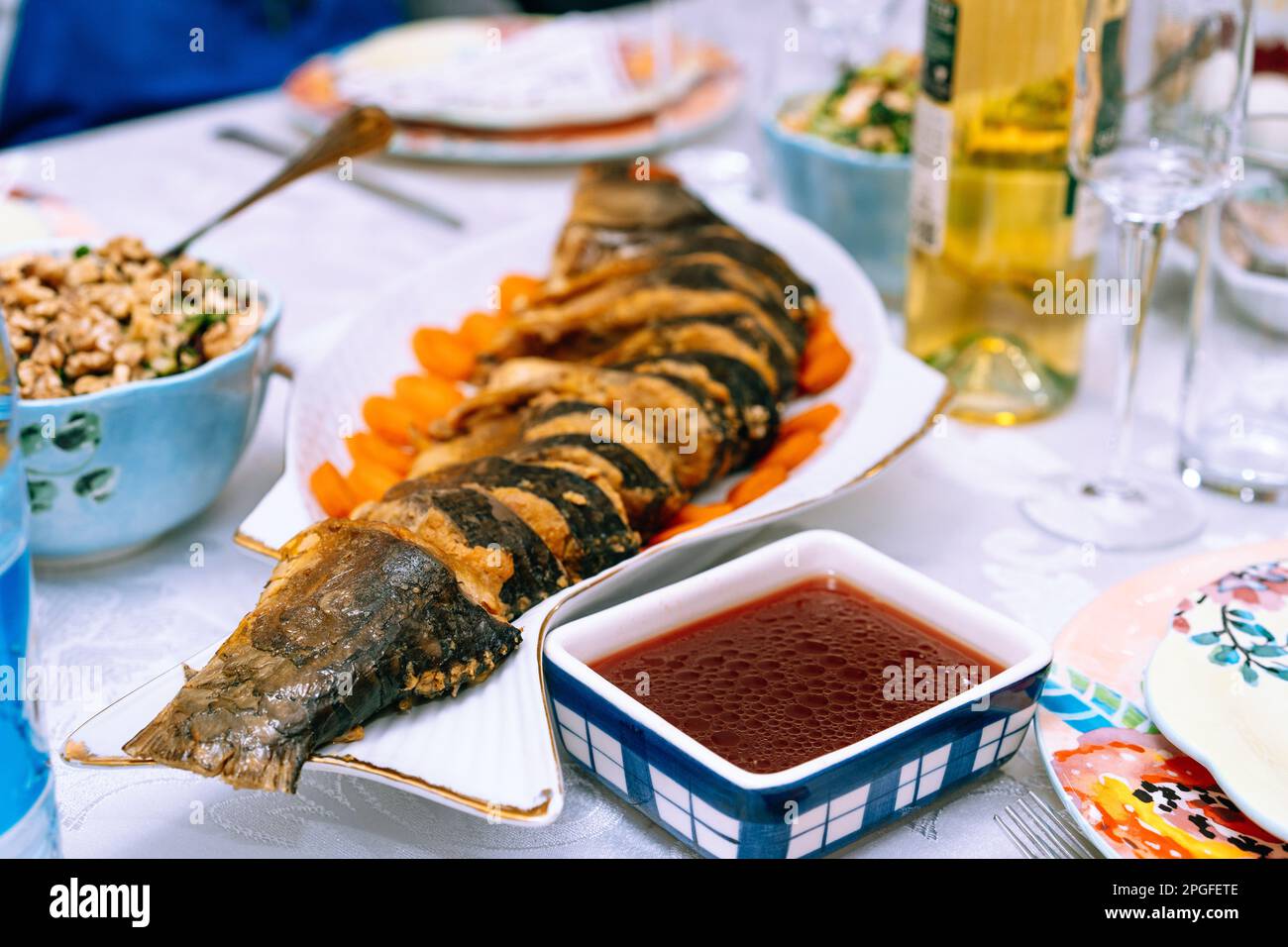 Pessachtisch mit traditionellem Pessachttteller. Gefilte Fish ist ein Gericht aus einer pochierten Mischung aus gemahlenem entbeintem Fisch. Es wird traditionell auf Sabbat und jüdischem Feiertagspasssover serviert. Stockfoto
