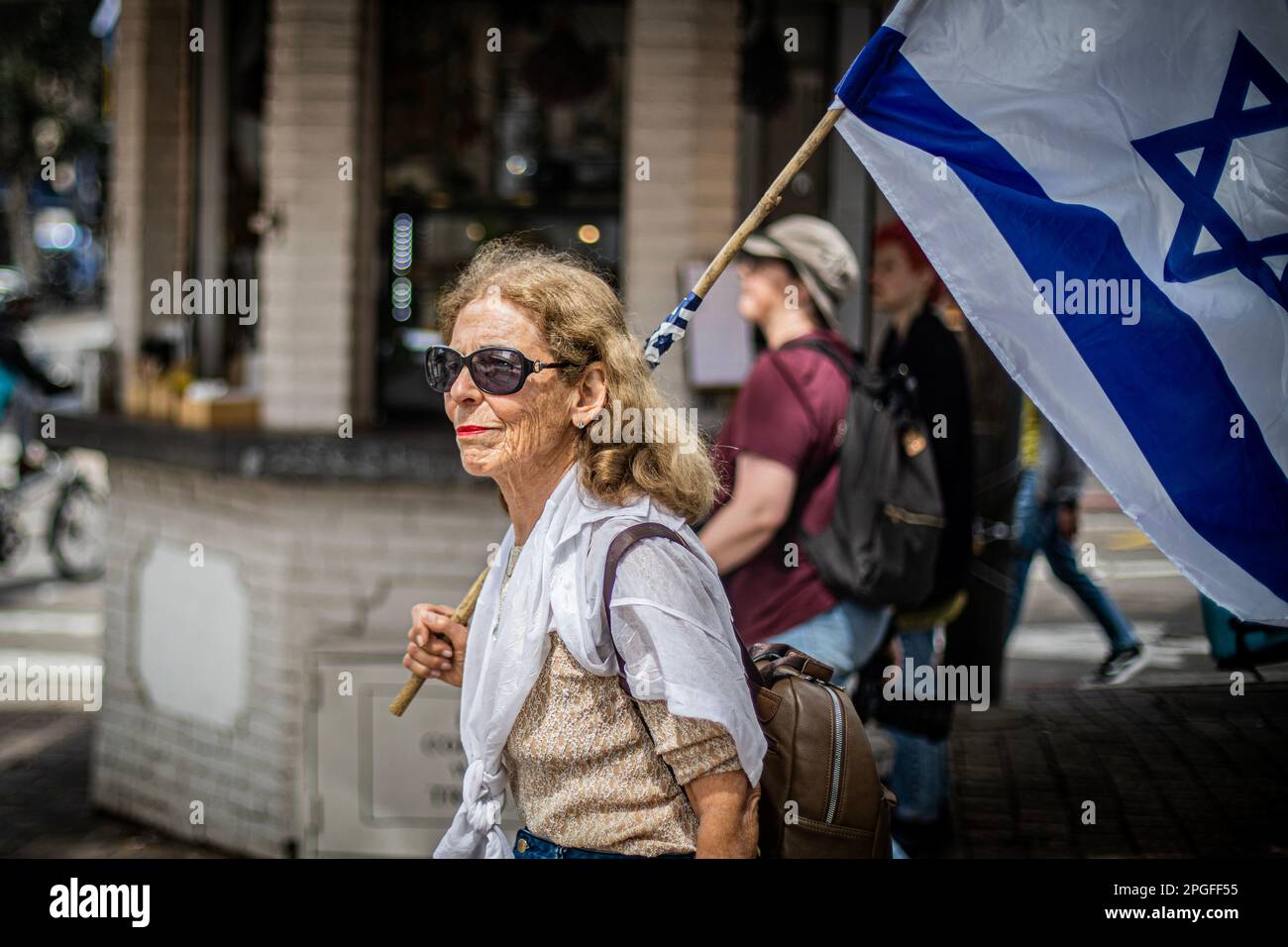 Tel Aviv, Israel. 22. März 2023. Eine ältere Frau hält während eines Protests gegen die Justizreform die israelische Flagge. In Jerusalem und Tel Aviv fanden Proteste gegen die Justizreform der Regierung statt, wobei mehrere Regierungsminister ins Visier genommen wurden, als die Koalition ihre umstrittenen Pläne vorantreibt. Kredit: SOPA Images Limited/Alamy Live News Stockfoto