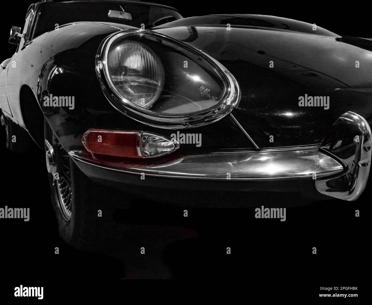 Dramatische Nahaufnahme eines klassischen Jaguar E-Type Sportwagens mit markantem versenktem Scheinwerfer. Stockfoto