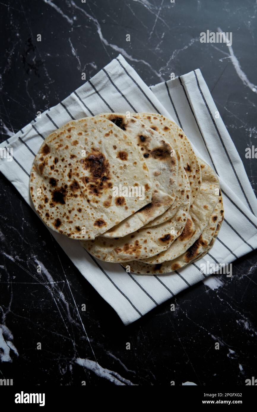 Gebratenes Pita-Brot in der Pfanne auf dunklem Hintergrund. Draufsicht Stockfoto
