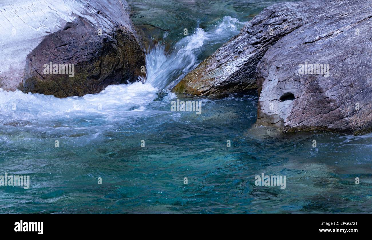 Die lebendige Schönheit und das schöne Blau des McDonald Creek-Wassers, das durch Felsen stürzt, sehen Sie von der Sun Road im Glacier-Nationalpark, Montana Stockfoto