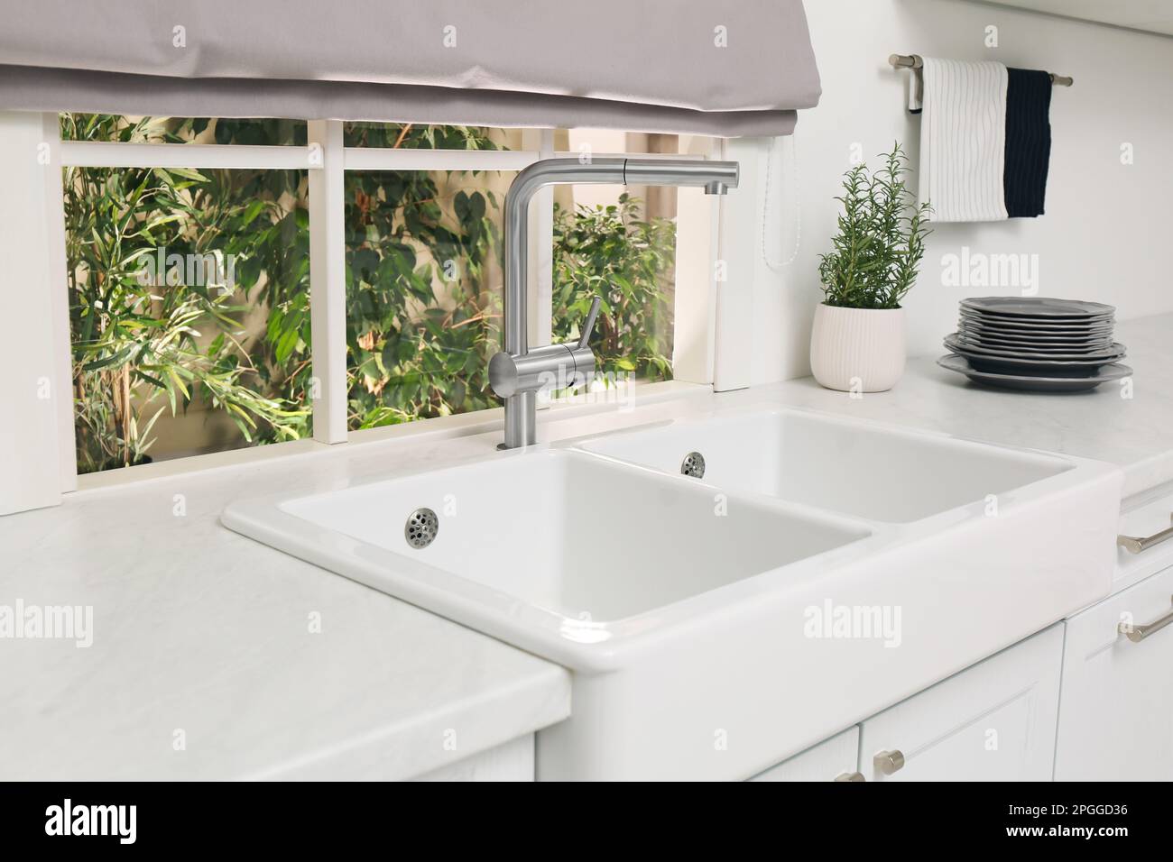 Weiße Doppelschüssel, Küchenspüle vor dem Fenster Stockfoto