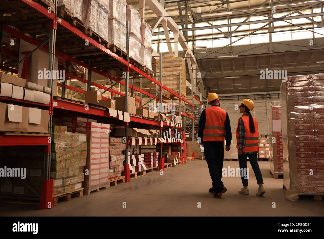 Manager und Arbeiter im Lager, Rückansicht. Logistikzentrum Stockfoto